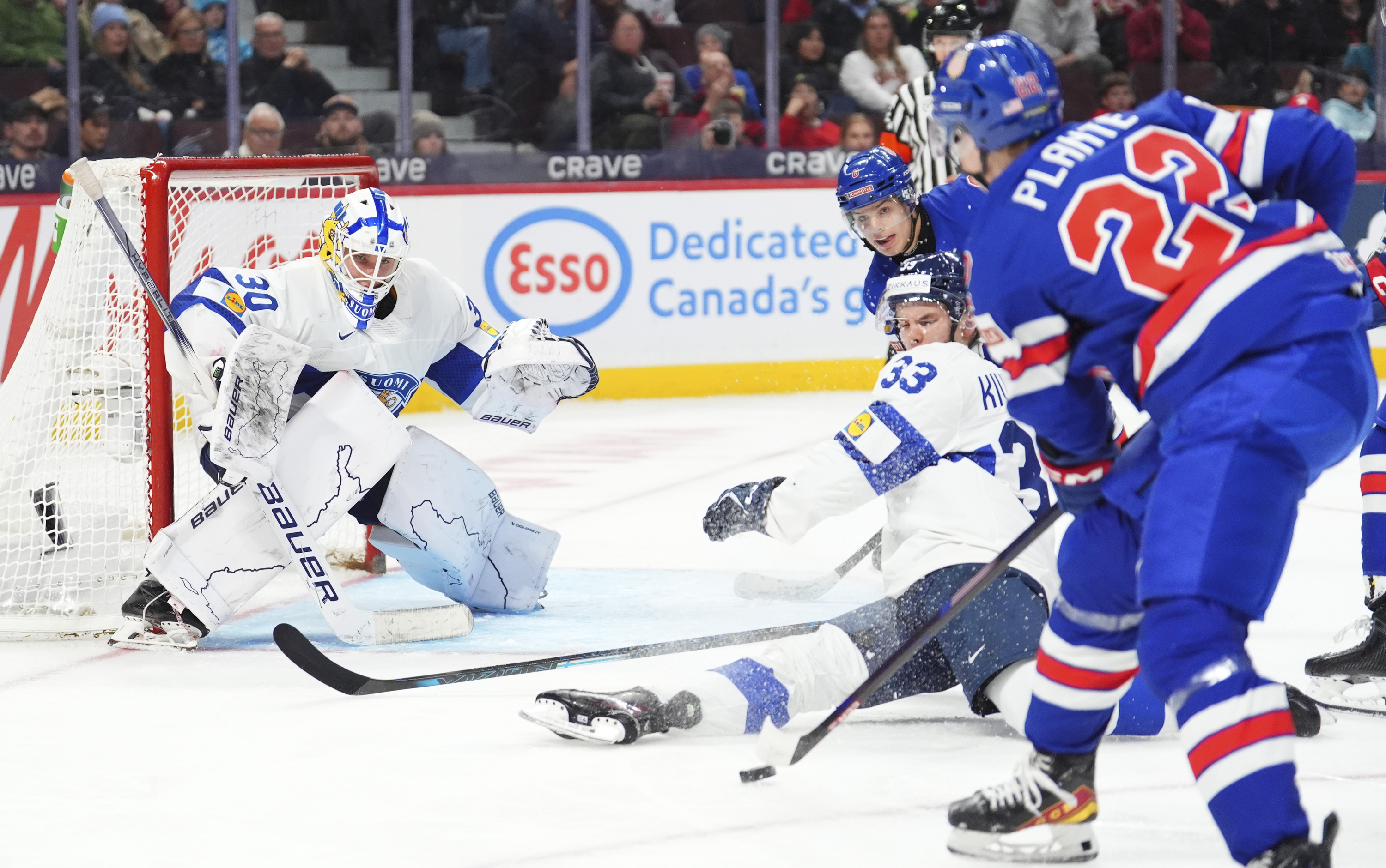 Finland defenseman Aron Kiviharju (33) blocks a shot against teammate Petteri Rimpinen (30) as United States forward Brandon Svoboda (8) and Max Plante (22) rush the net during third -period IIHF World Junior Hockey Championship gold medal game action in Ottawa, Ontario, Sunday, Jan. 5, 2025. 