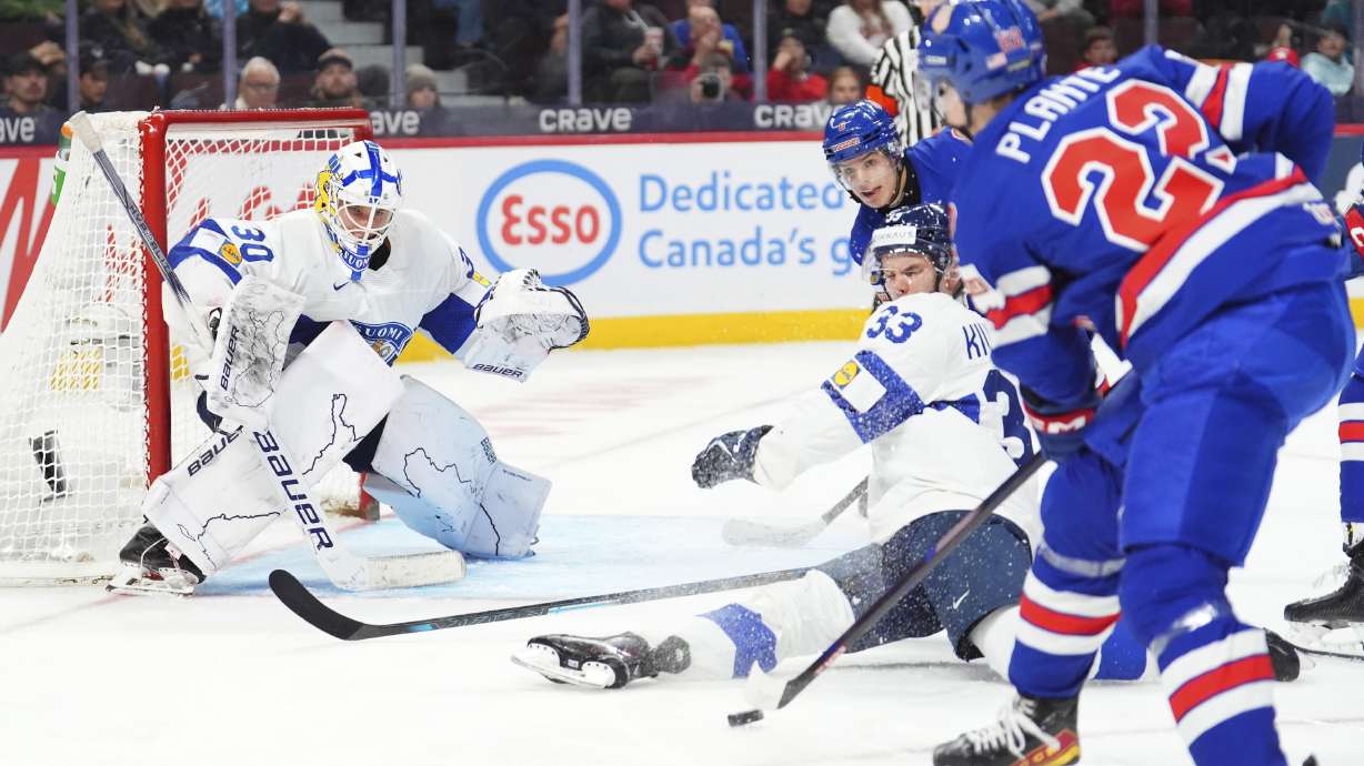 Finland defenseman Aron Kiviharju (33) blocks a shot against teammate Petteri Rimpinen (30) as United States forward Brandon Svoboda (8) and Max Plante (22) rush the net during third -period IIHF World Junior Hockey Championship gold medal game action in Ottawa, Ontario, Sunday, Jan. 5, 2025.