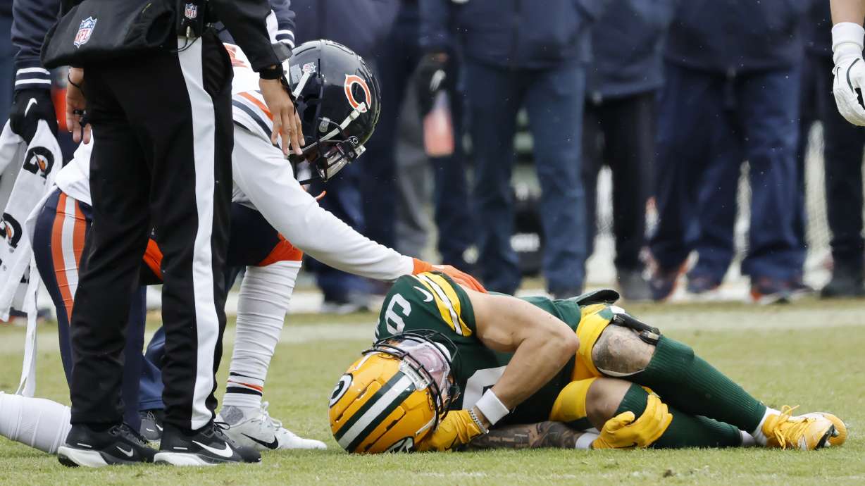 Green Bay Packers wide receiver Christian Watson, bottom, is checked on by a Chicago Bears player during the first half of an NFL football game, Sunday, Jan. 5, 2025, in Green Bay, Wis.