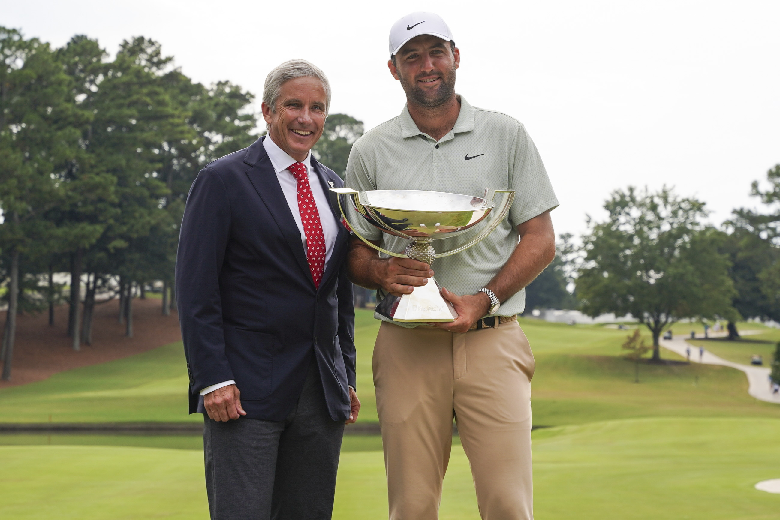 FILE - PGA Tour Commissioner Jay Monahan, left, poses with Scottie Scheffler and the FedExCup Trophy after Scheffler won the final round of the Tour Championship golf tournament, Sunday, Sept. 1, 2024, in Atlanta.