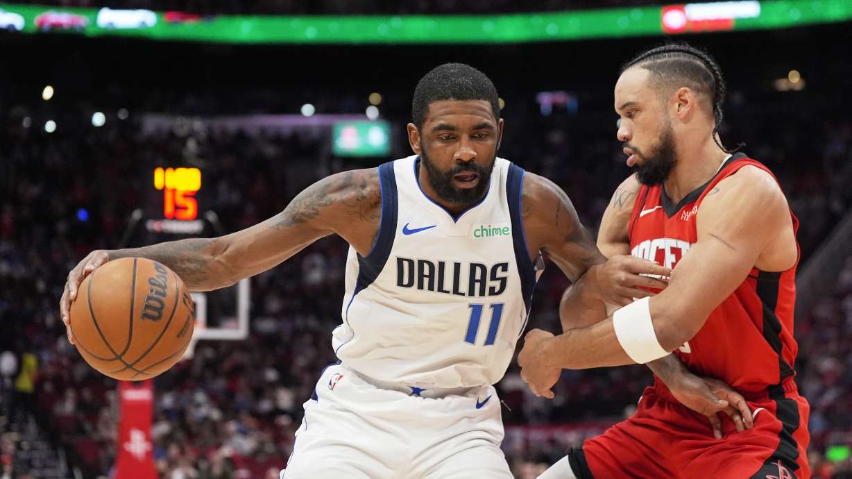 Dallas Mavericks' Kyrie Irving (11) is defended by Houston Rockets' Dillon Brooks during the first half of an NBA basketball game Wednesday, Jan. 1, 2025, in Houston.