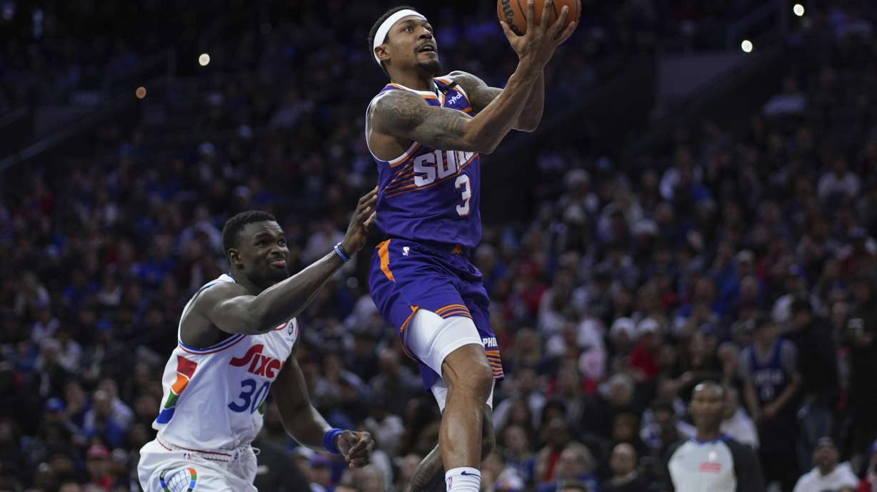 Phoenix Suns' Bradley Beal, right, goes up for a shot against Philadelphia 76ers' Adem Bona during the second half of an NBA basketball game, Monday, Jan. 6, 2025, in Philadelphia.