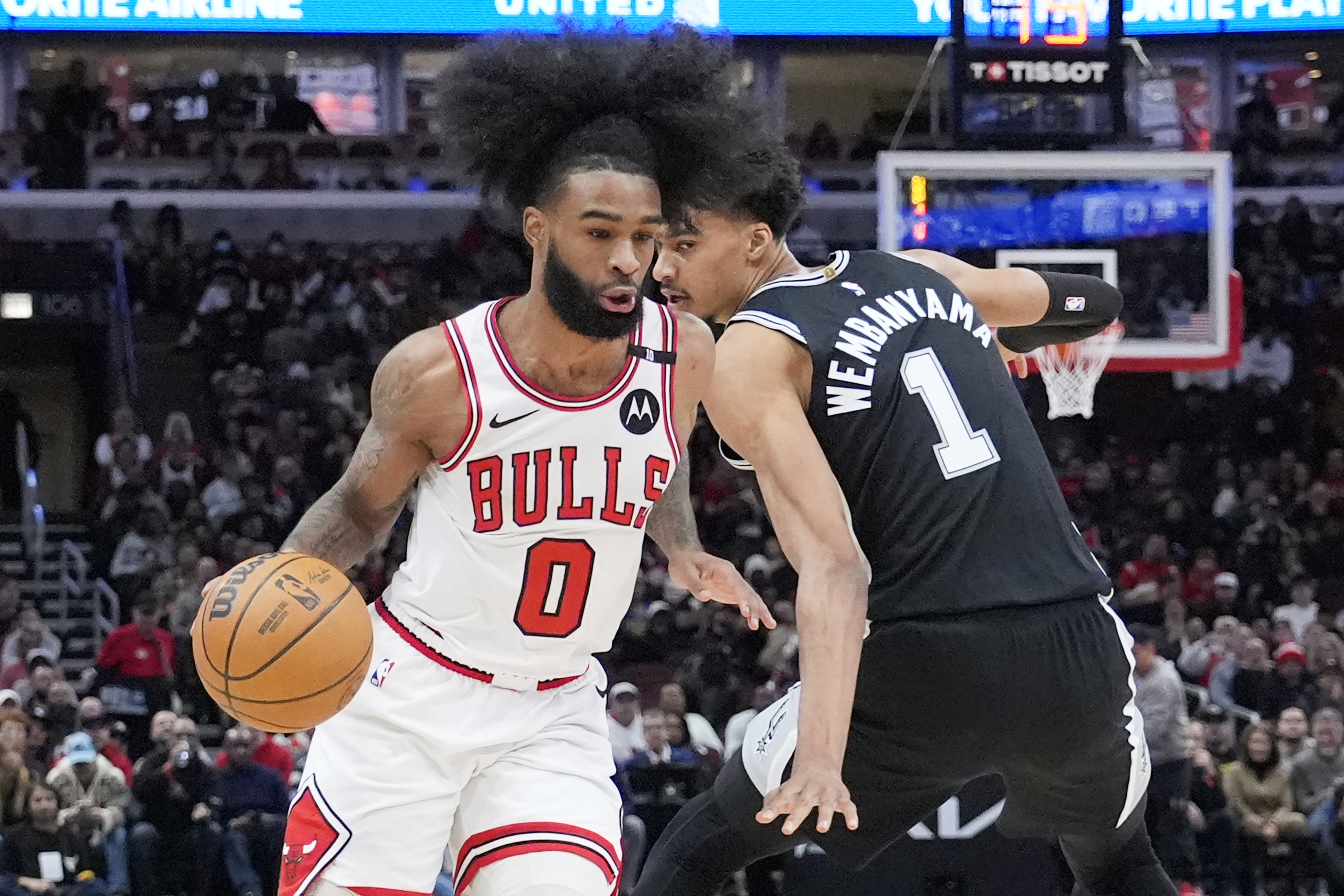 Chicago Bulls guard Coby White, left, drives to the basket past San Antonio Spurs center Victor Wembanyama, right, during the first half of an NBA basketball game in Chicago, Monday, Jan. 6, 2025.
