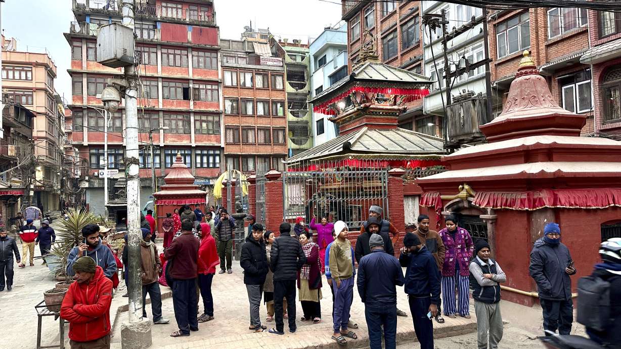 Nepalese people stand after rushing out of their homes after experiencing an earthquake in Kathmandu, Nepal, Tuesday.