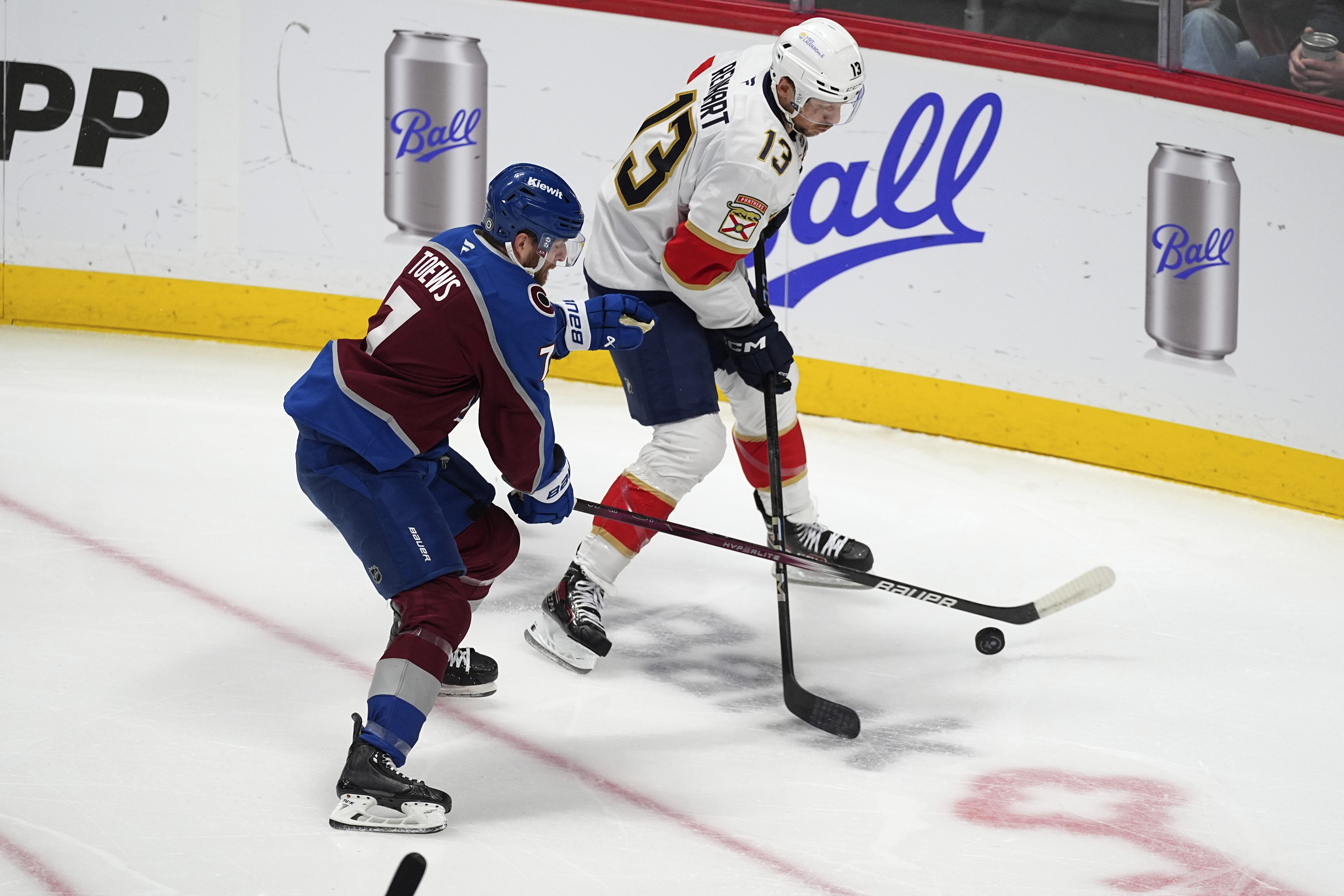 Colorado Avalanche defenseman Devon Toews, left, fights for control of the puck with Florida Panthers center Sam Reinhart, right, in the first period of an NHL hockey game Monday, Jan. 6, 2025, in Denver.
