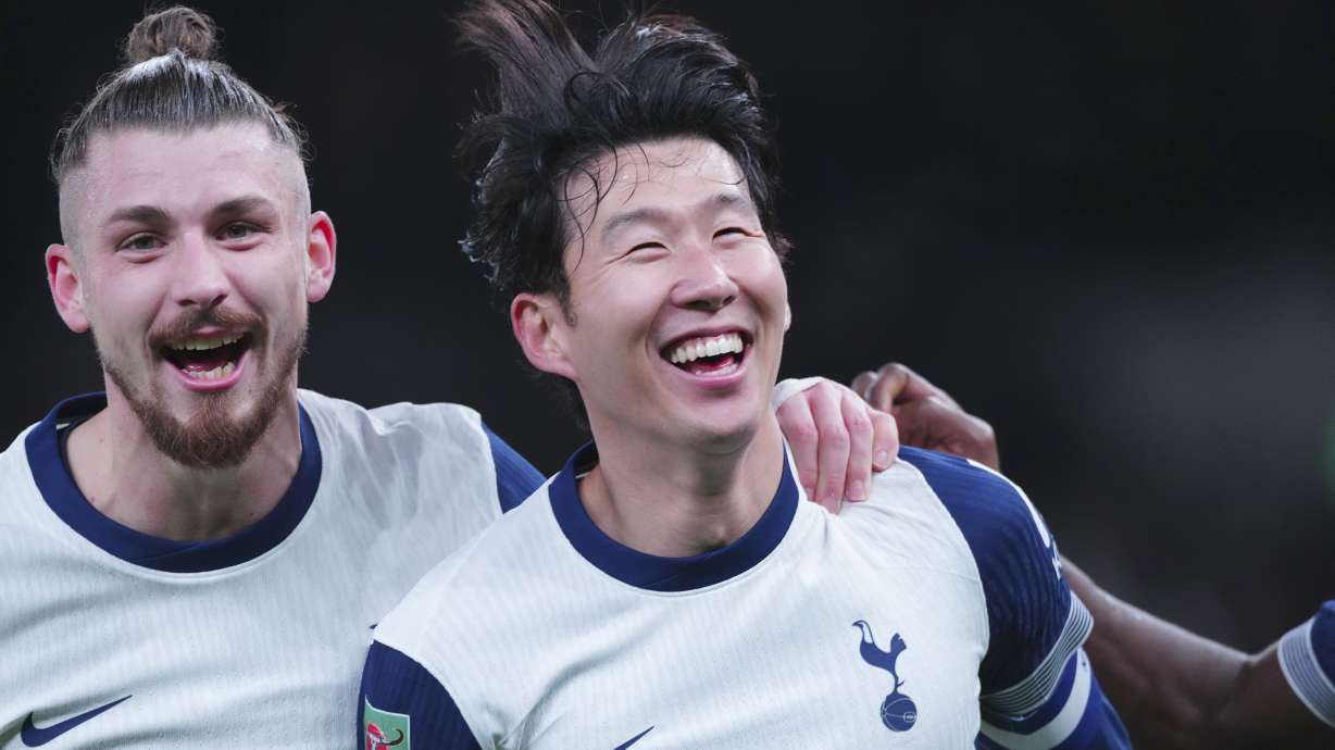 Tottenham's Son Heung-min, right, celebrates after scoring his side's fourth goal during the English League Cup quarter-final soccer match between Tottenham and Manchester United, at the Tottenham Hotspur Stadium in London, Thursday, Dec. 19, 2024.