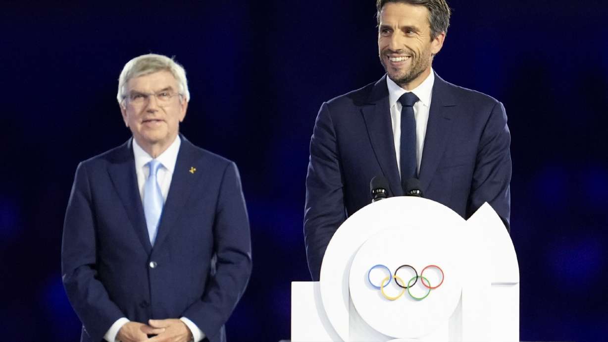 FILE - The President of the Paris 2024 Organizing Committee, Tony Estanguet, right, addresses the audience as IOC President Thomas Bach, left, watches during the 2024 Summer Olympics closing ceremony at the Stade de France, Sunday, Aug. 11, 2024, in Saint-Denis, France.