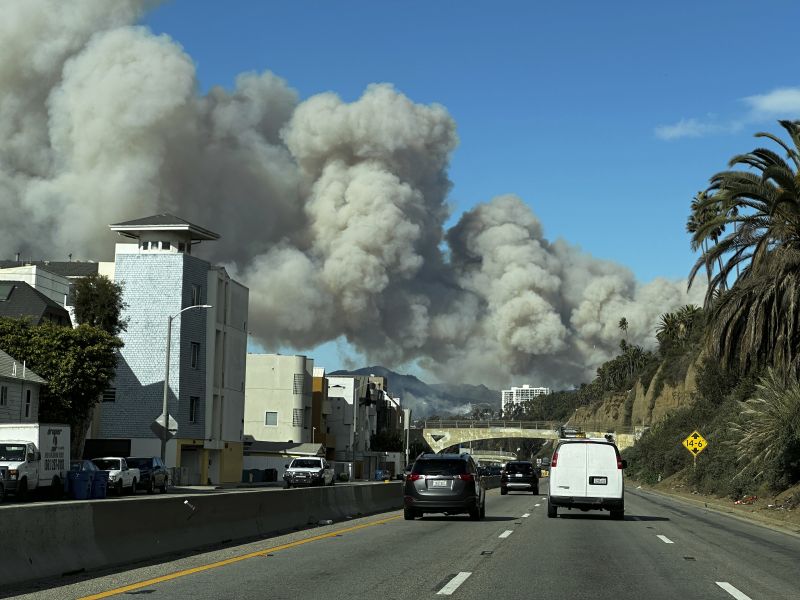 Heavy smoke from a brush fire in the Pacific Palisades rises over the Pacific Coast Highway in Santa Monica, Calif., on Tuesday.