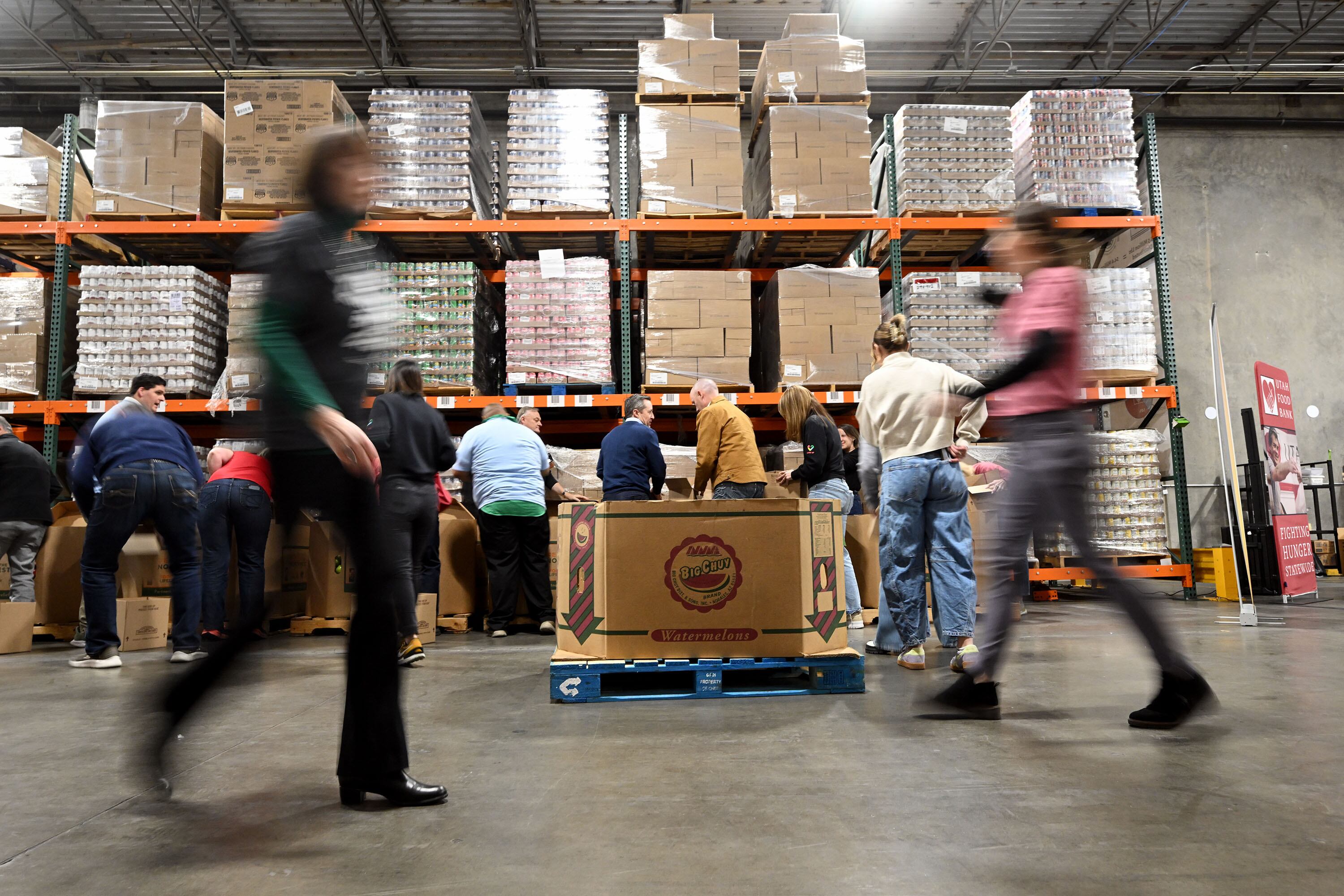 State employees and officials sort food items along with Gov. Spencer and first lady Abby Cox at the Utah Food Bank to serve in Salt Lake City on Tuesday.