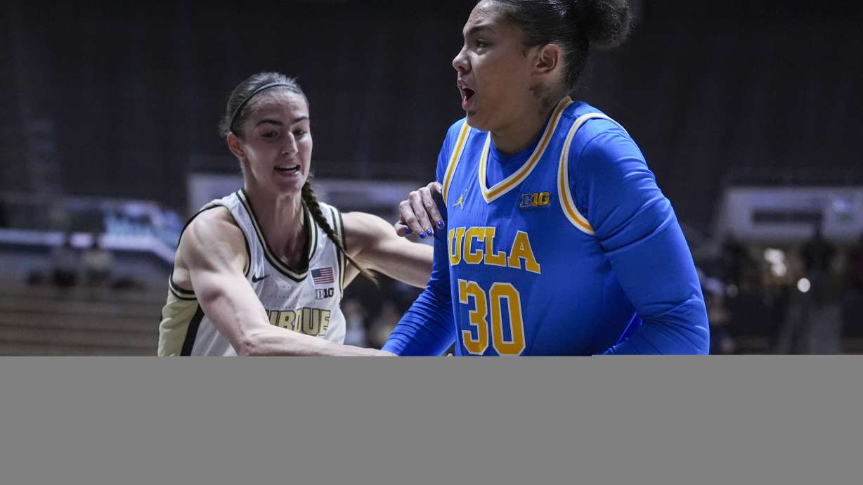 Purdue forward Reagan Bass (34) tries to tie up UCLA forward Timea Gardiner (30) in the first half of an NCAA college basketball game in West Lafayette, Ind., Tuesday, Jan. 7, 2025.