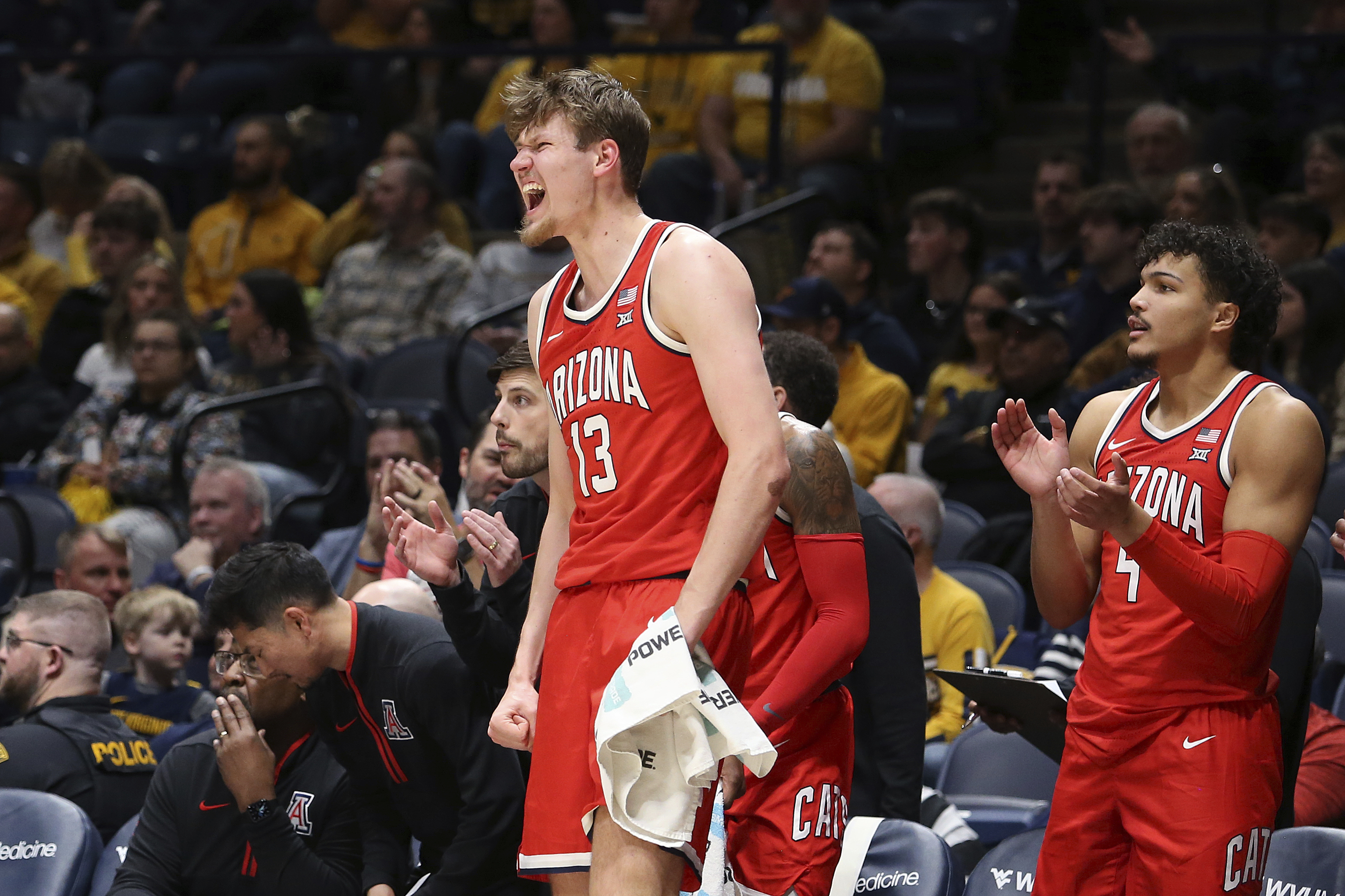 Arizona guard Will Kuykendall (12) and forward Trey Townsend (4) react from the bench during the first half of an NCAA college basketball game against West Virginia, Tuesday, Jan. 7, 2025, in Morgantown, W.Va.