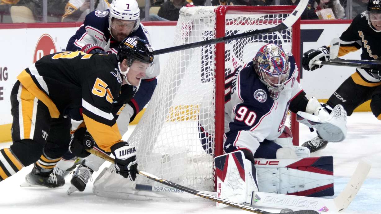 Pittsburgh Penguins' Noel Acciari (55) can't get a wrap around shot past Columbus Blue Jackets goaltender Elvis Merzlikins (90) with Sean Kuraly (7) defending during the second period of an NHL hockey game in Pittsburgh, Tuesday, Jan. 7, 2025.