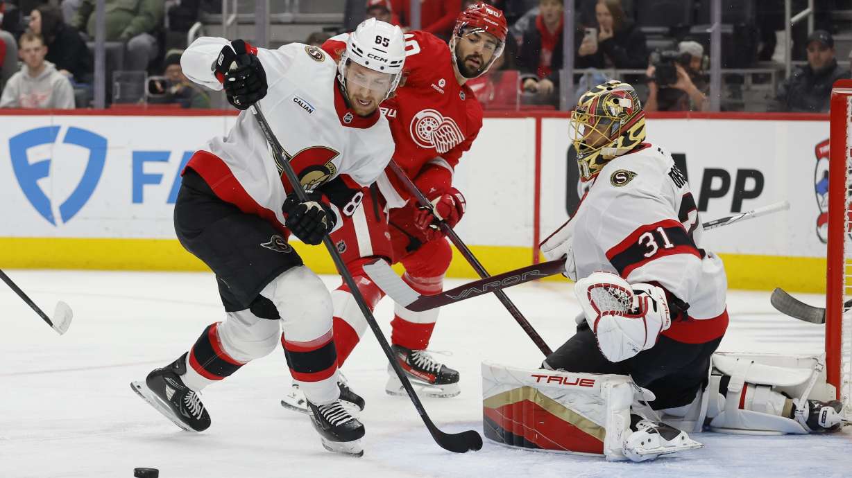 Ottawa Senators defenseman Jake Sanderson (85) stops a shot on goaltender Anton Forsberg (31) with Detroit Red Wings center Joe Veleno, center, working in front of the net during the second period of an NHL hockey game Tuesday, Jan. 7, 2025, in Detroit.