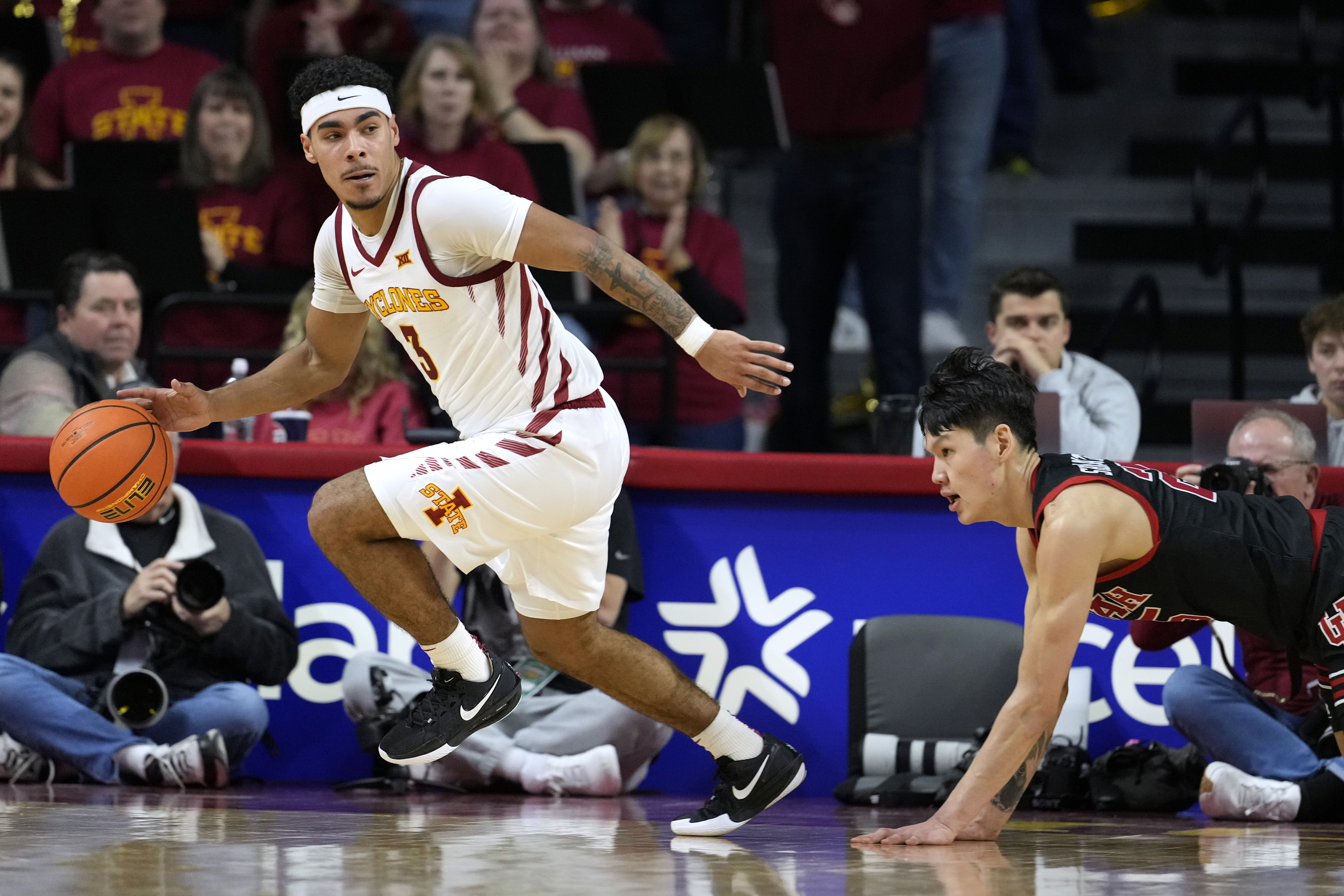 Iowa State guard Tamin Lipsey (3) runs down a loose ball ahead of Utah guard Mike Sharavjamts, right, during the first half of an NCAA college basketball game Tuesday, Jan. 7, 2025, in Ames, Iowa.