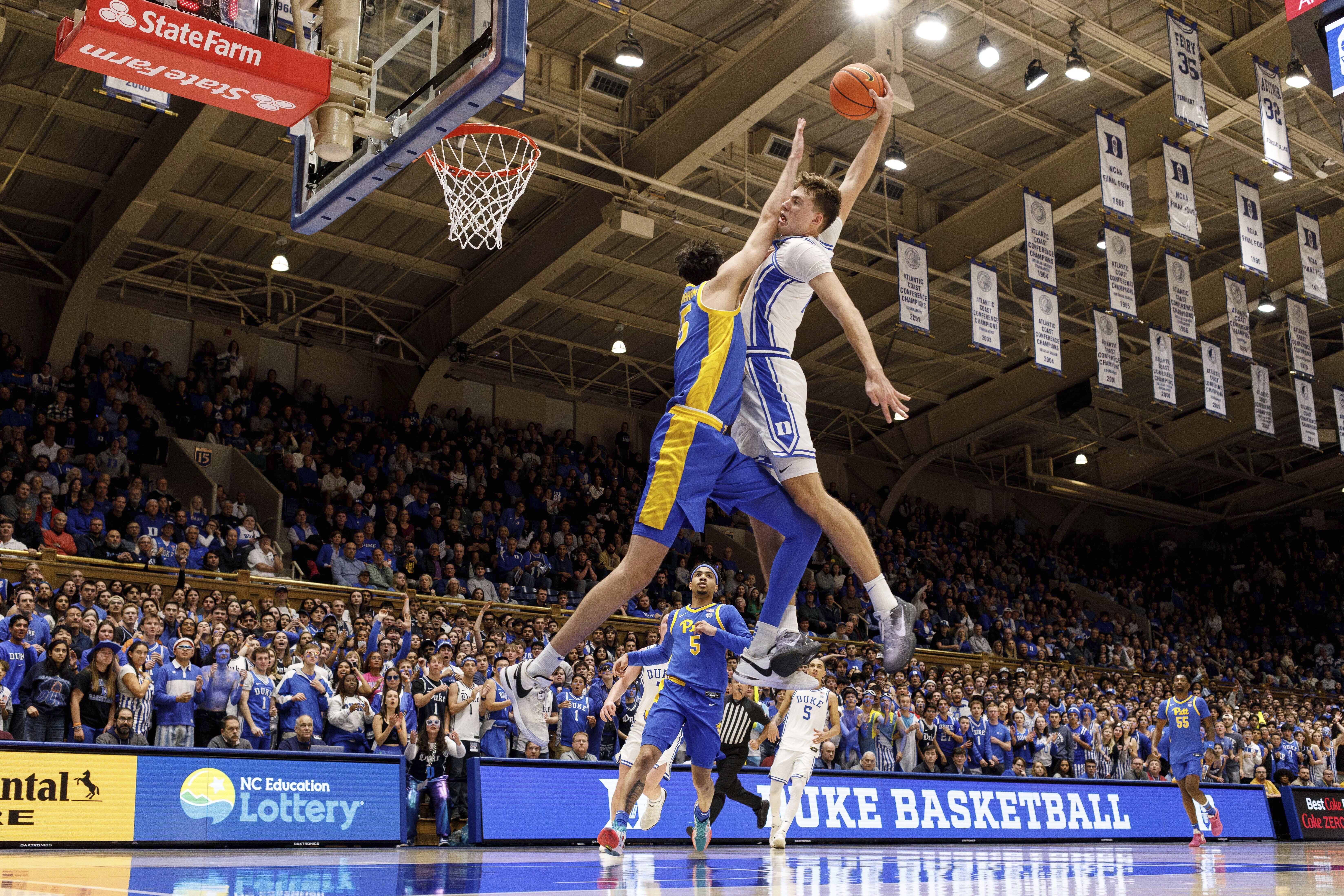 Duke's Cooper Flagg, right, dunks over Pittsburgh's Guillermo Diaz Graham (25) during the second half of an NCAA college basketball game in Durham, N.C., Tuesday, Jan. 7, 2025. 