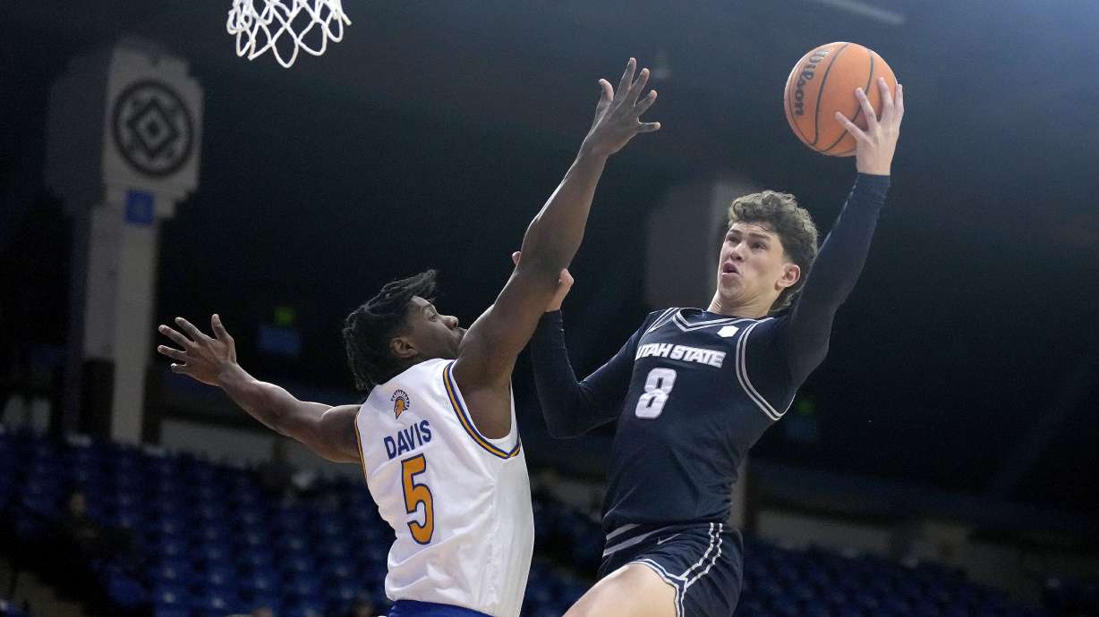 Utah State guard Drake Allen (8) drives to the basket against San Jose State guard Latrell Davis (5) during the first half of an NCAA college basketball game Tuesday, Jan. 7, 2025, in San Jose, Calif.