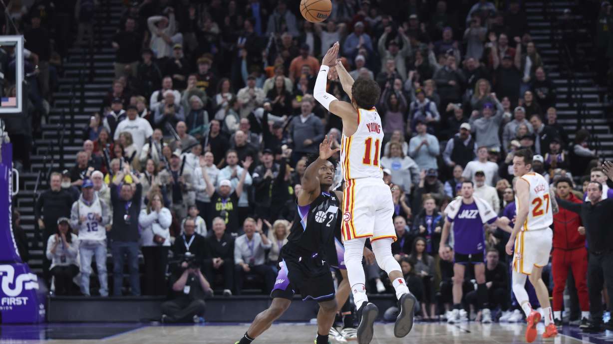 Atlanta Hawks guard Trae Young (11) shoots a three point shot from half court over Utah Jazz guard Collin Sexton (2) at the buzzer to win an NBA basketball game, Tuesday, Jan. 7, 2025, in Salt Lake City.