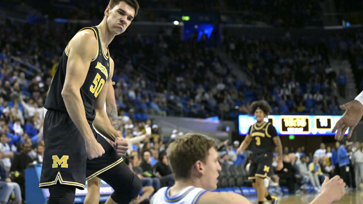 Michigan center Vladislav Goldin (50) reacts after a dunk over UCLA forward Tyler Bilodeau during the first half of an NCAA college basketball game, Tuesday, Jan. 7, 2025, in Los Angeles.