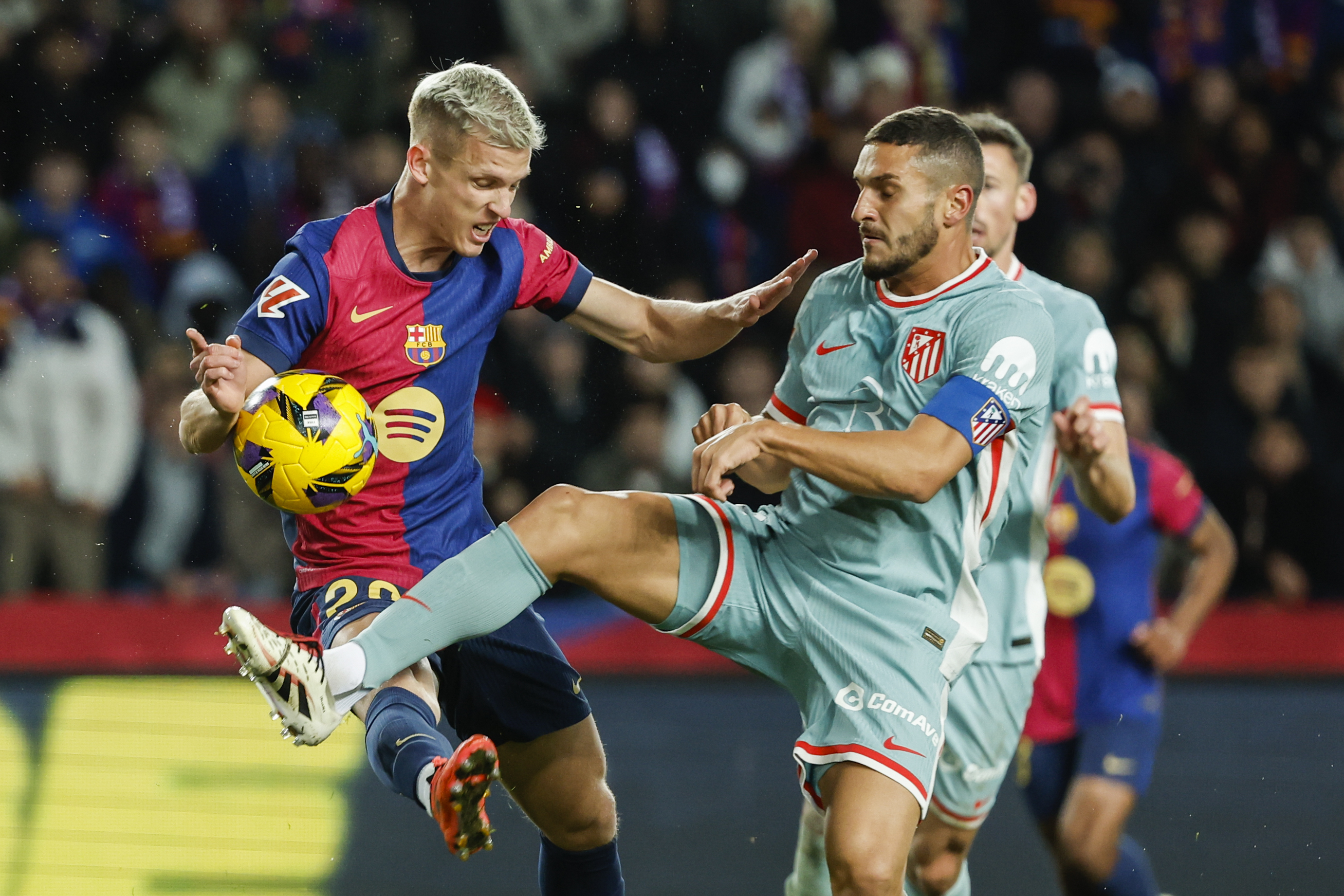 Barcelona's Dani Olmo, left, duels for the ball with Atletico Madrid's Koke during the Spanish La Liga soccer match between Barcelona and Atletico Madrid at the Lluis Companys Olympic Stadium in Barcelona, Spain, Saturday, Dec. 21, 2024. 