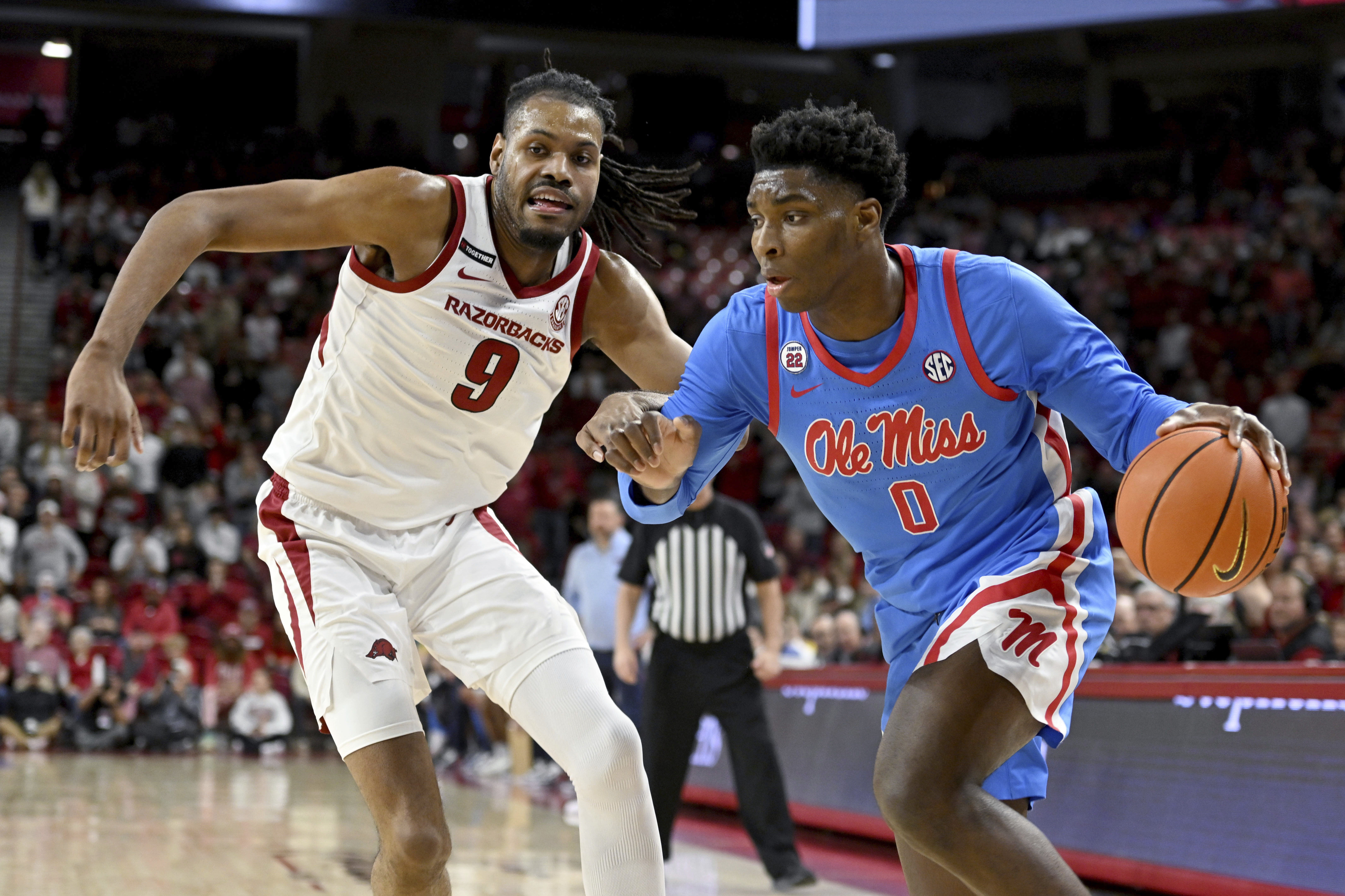 Mississippi forward Malik Dia (0) tries to drive past Arkansas forward Jonas Aidoo (9) during the first half of an NCAA college basketball game, Wednesday, Jan. 8, 2025, in Fayetteville, Ark.