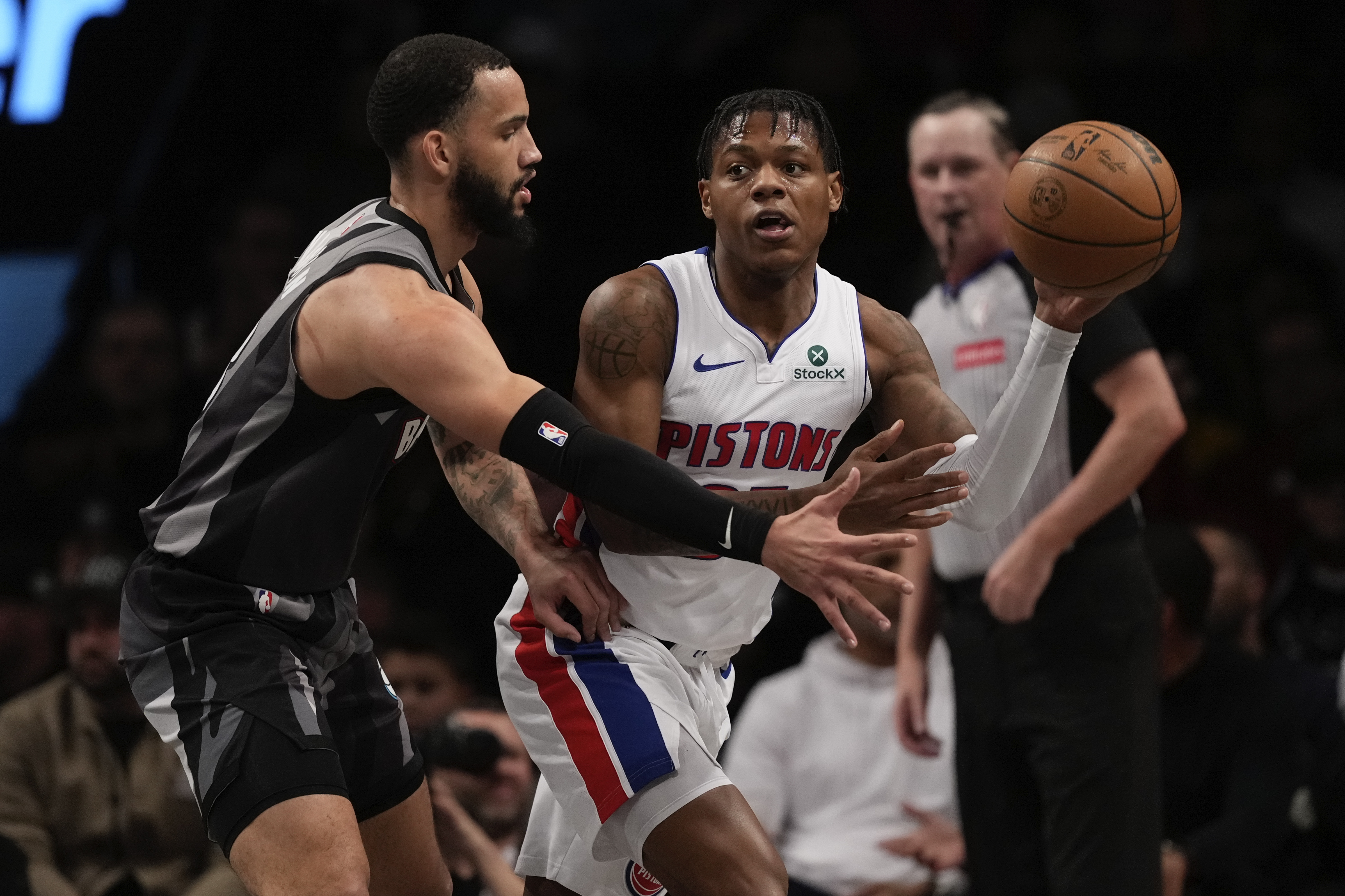 Detroit Pistons' Marcus Sasser (25) passes away from Brooklyn Nets' Tyrese Martin (13) during the first half of an NBA basketball game, Wednesday, Jan. 8, 2025, in New York.