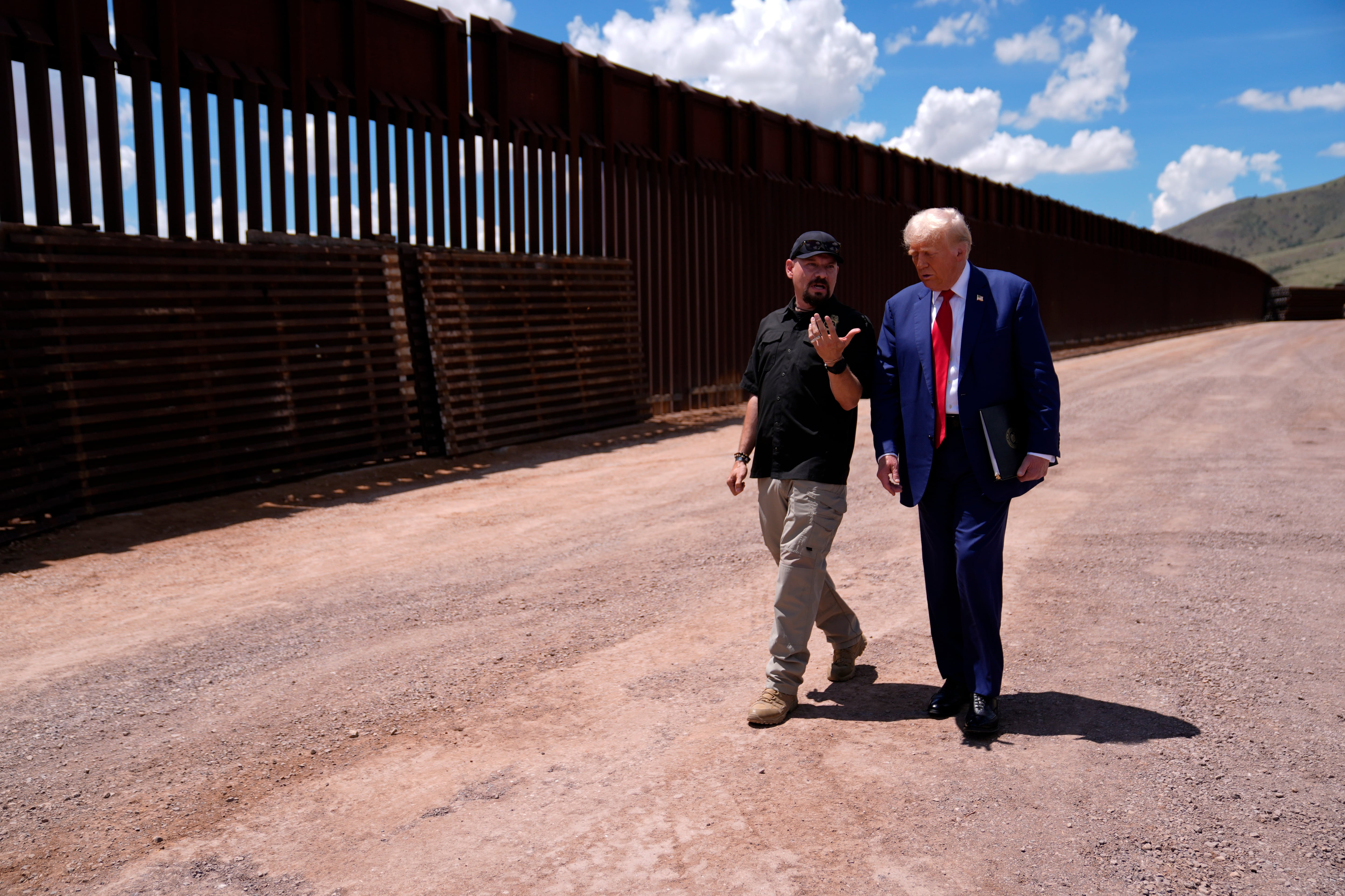 President-elect Donald Trump speaks while walking along the U.S.-Mexico border, Aug. 22, 2024, in Sierra Vista, Ariz., as Paul Perez, president of the National Border Patrol Council, listens.