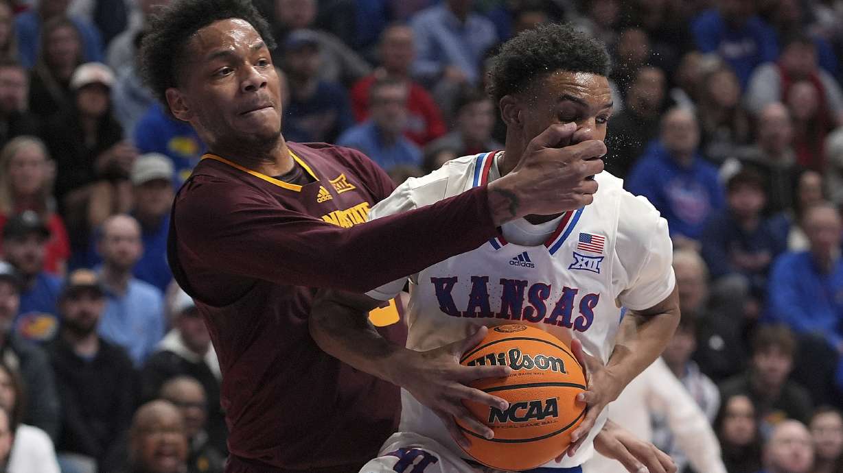 Kansas guard Rylan Griffen, right, looks to shoot under pressure from Arizona State guard BJ Freeman during the first half of an NCAA college basketball game, Wednesday, Jan. 8, 2025, in Lawrence, Kan.