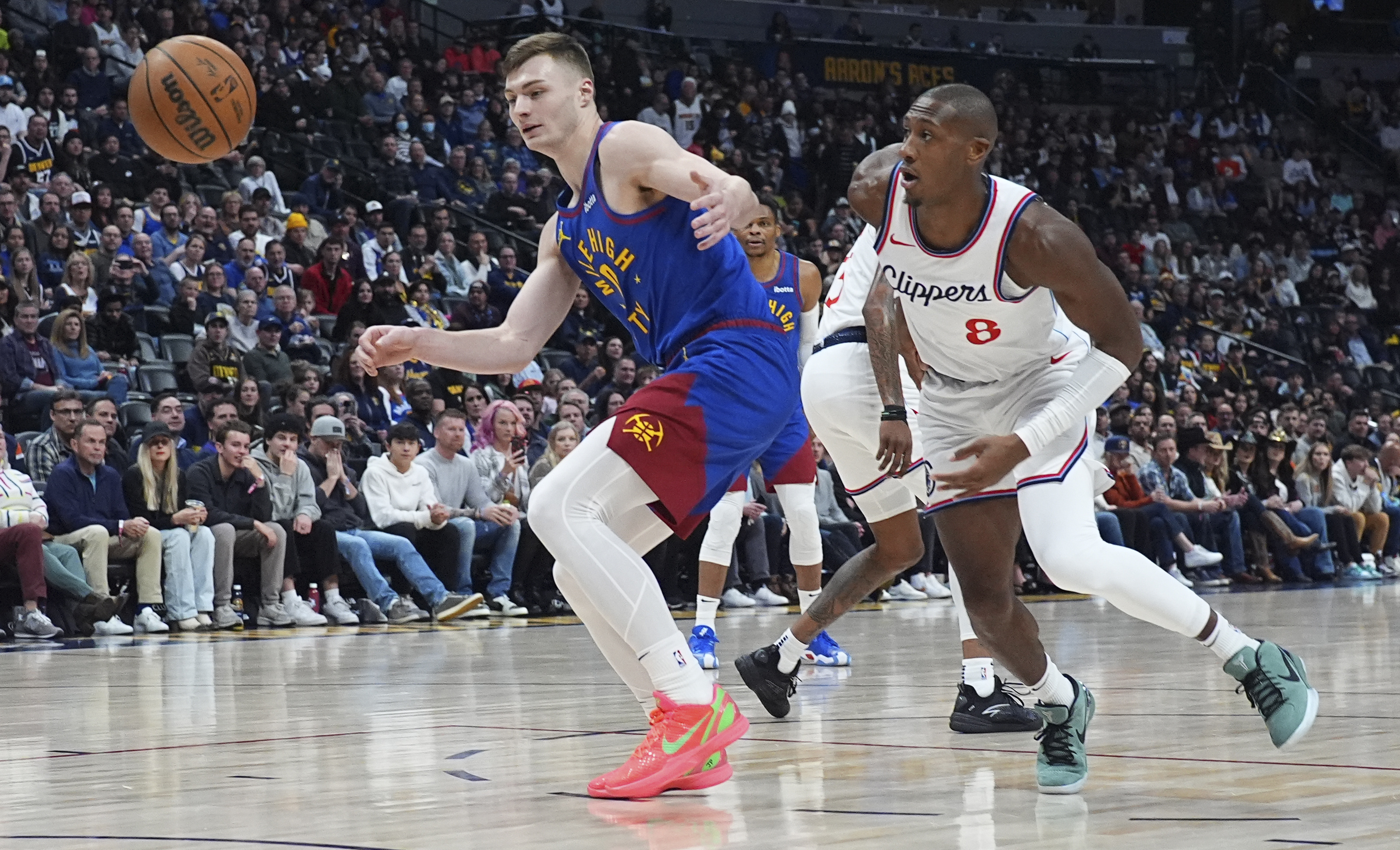 Denver Nuggets guard Christian Braun, left, and Los Angeles Clippers guard Kris Dunn pursue a loose ball in the first half of an NBA basketball game Wednesday, Jan. 8, 2025, in Denver.