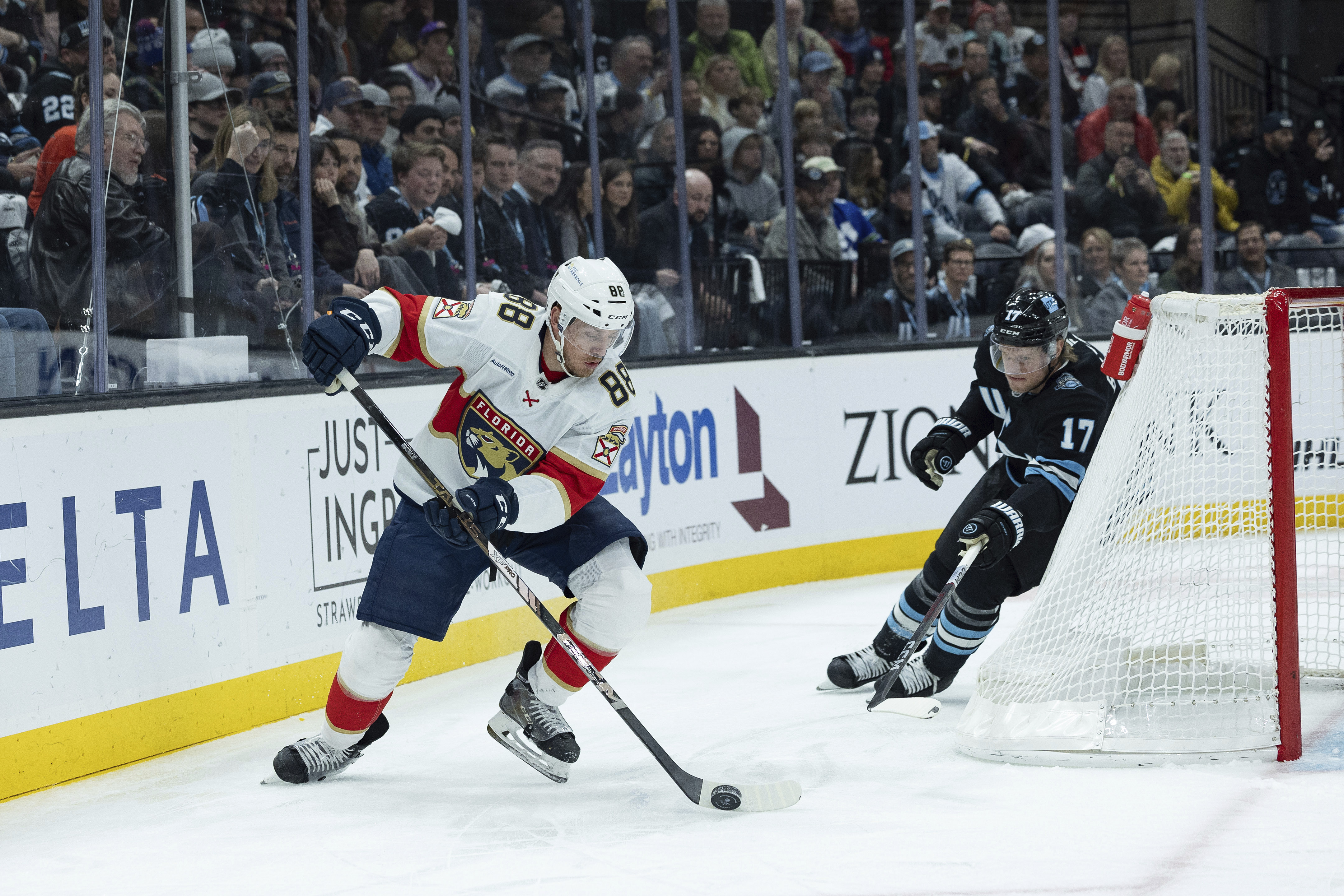 Florida Panthers defenseman Nate Schmidt (88) moves the puck against Utah Hockey Club center Nick Bjugstad (17) during the first period of an NHL hockey game, Wednesday, Jan. 8, 2025, in Salt Lake City.