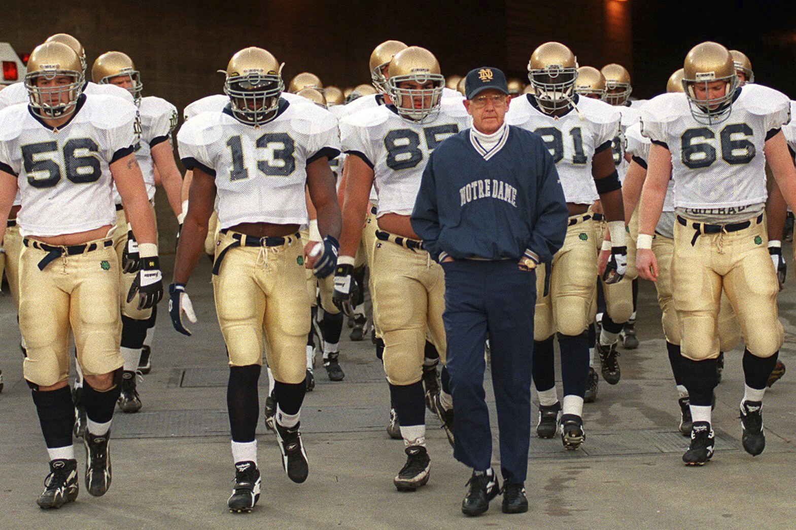 FILE - Notre Dame's head coach Lou Holtz and the Fighting Irish walk onto the field of the Los Angeles Coliseum to warm up for an NCAA college football game against Southern California Saturday, Nov. 30, 1996 in Los Angeles.