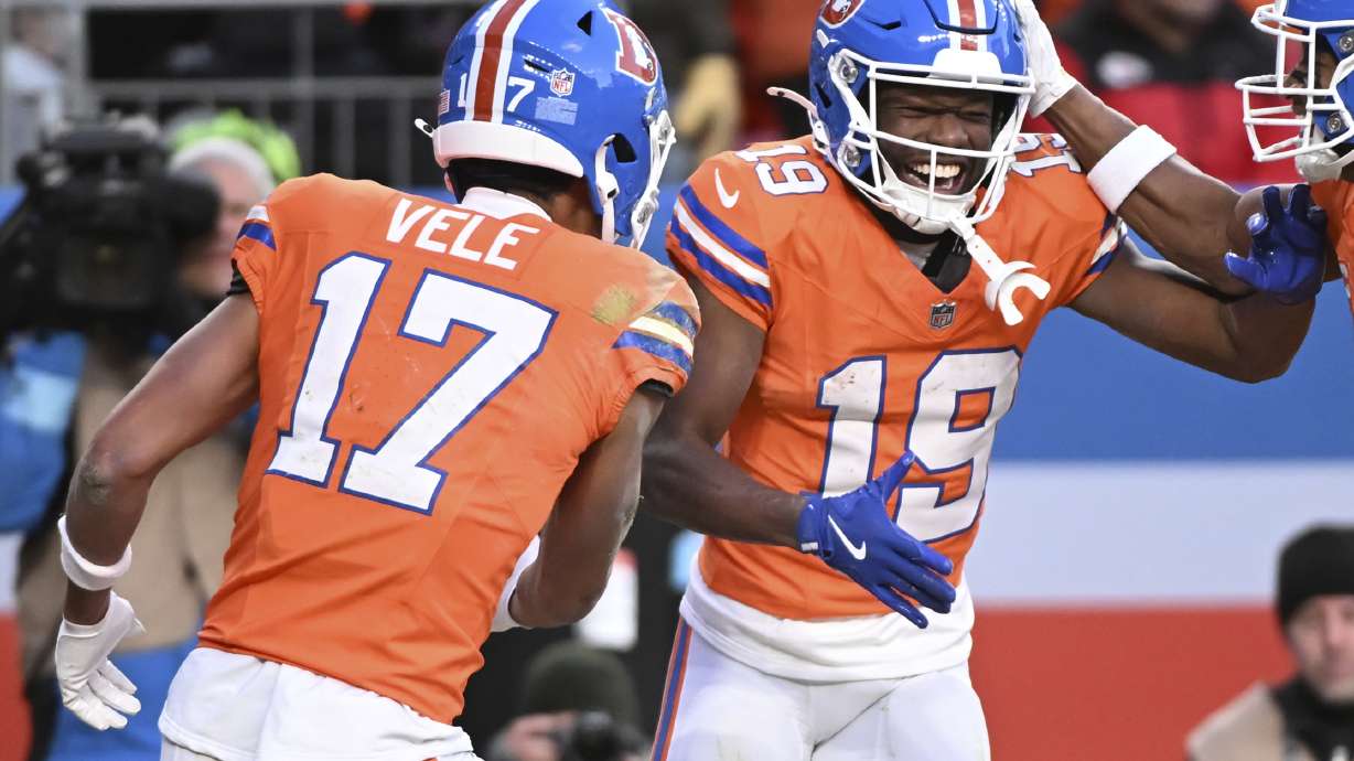 Denver Broncos wide receiver Marvin Mims Jr. (19) is congratulated by teammate Devaughn Vele (17) after scoring during the second half of an NFL football game against the Kansas City Chiefs Sunday, Jan. 5, 2025, in Denver.