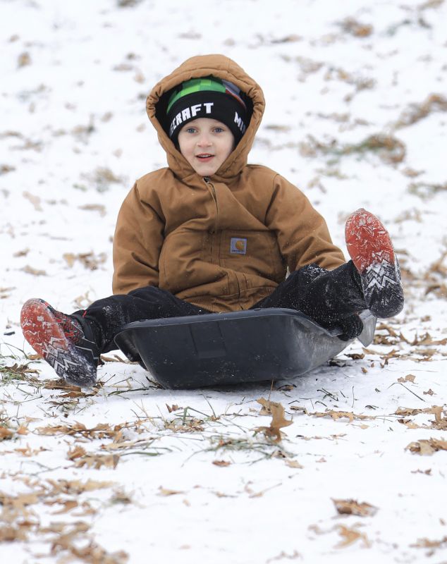 Taking advantage of the lingering ice and snow from the recent winter weather event, Dawson Mauro, 6, races down a steep hill behind Chautauqua Park while sledding, Wednesday, in Owensboro, Ky.