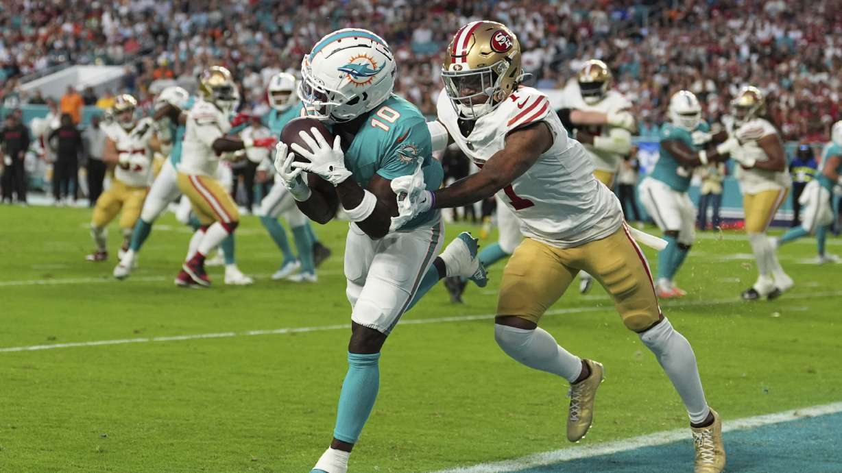 Miami Dolphins wide receiver Tyreek Hill (10) catches a pass for a touchdown as San Francisco 49ers cornerback Charvarius Ward (7) gives him a push during the first half of an NFL football game, Sunday, Dec. 22, 2024, in Miami Gardens, Fla.