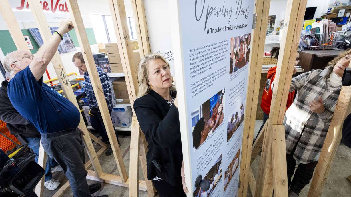 Carin Crowe, CEO of Habitat for Humanity Greater Salt Lake Area, and others sign a memorial wall for the late President Jimmy Carter at the Habitat for Humanity Salt Lake ReStore in Salt Lake City on Thursday.