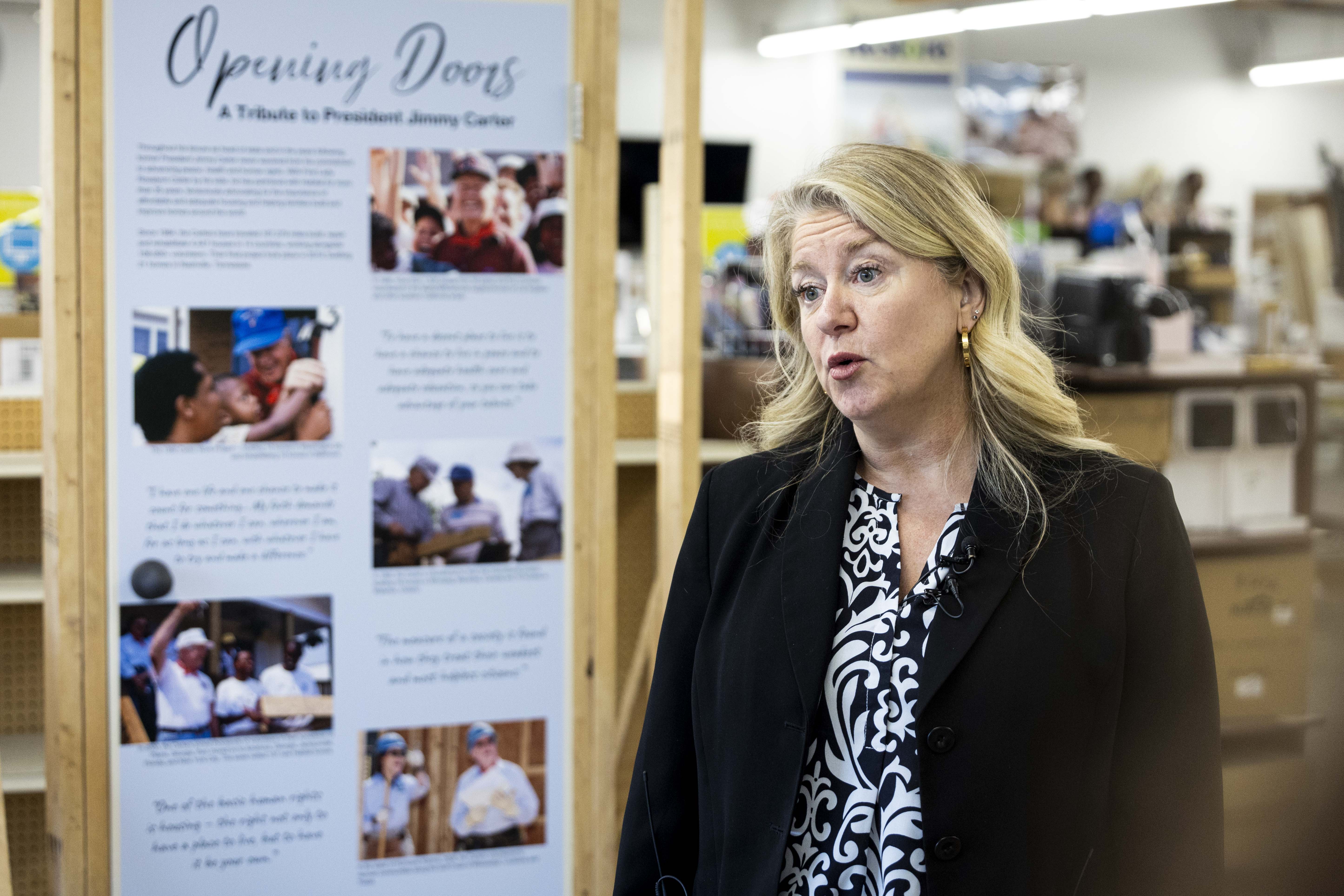 Carin Crowe, CEO of Habitat for Humanity Greater Salt Lake Area, speaks to members of the media by a memorial wall for the late President Jimmy Carter at the Habitat for Humanity Salt Lake ReStore in Salt Lake City on Thursday.