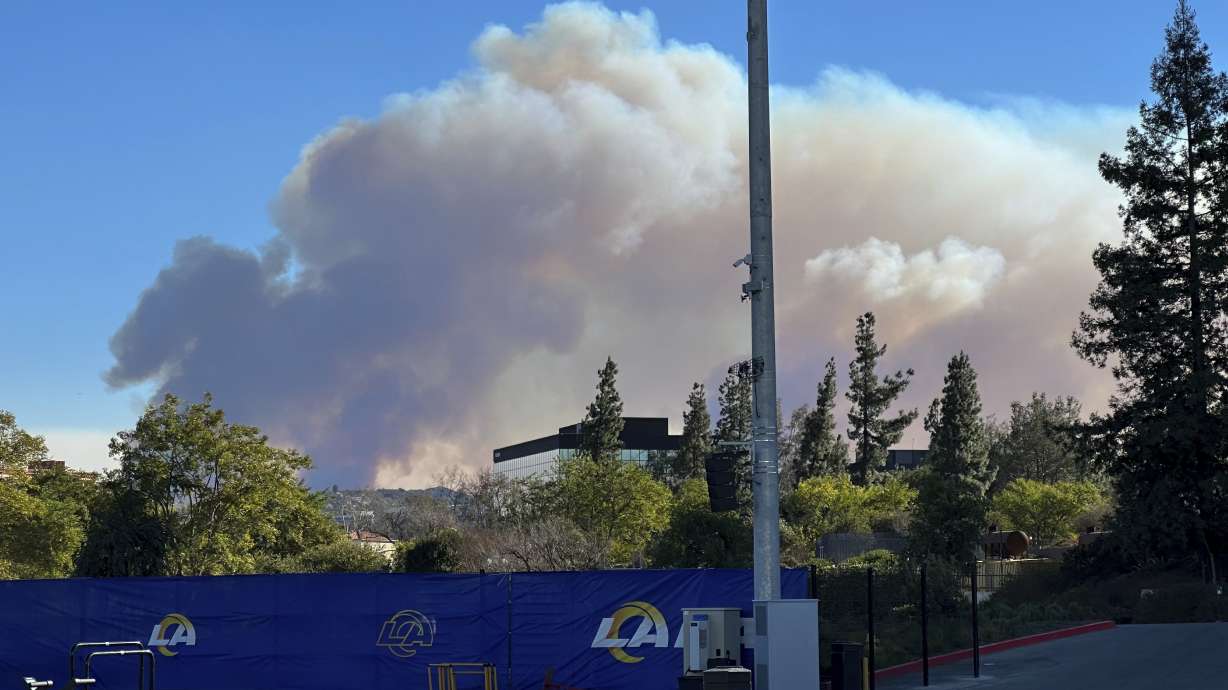 Smokes from a wildfire rises over the Los Angeles Rams NFL football practice facility in the Woodland Hills section of Los Angeles, Thursday, Jan. 9, 2025.