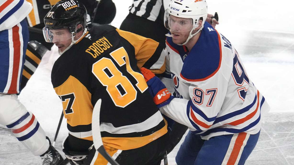 Pittsburgh Penguins' Sidney Crosby (87) and Edmonton Oilers' Connor McDavid (97) compete during the first period of an NHL hockey game in Pittsburgh, Thursday, Jan. 9, 2025.