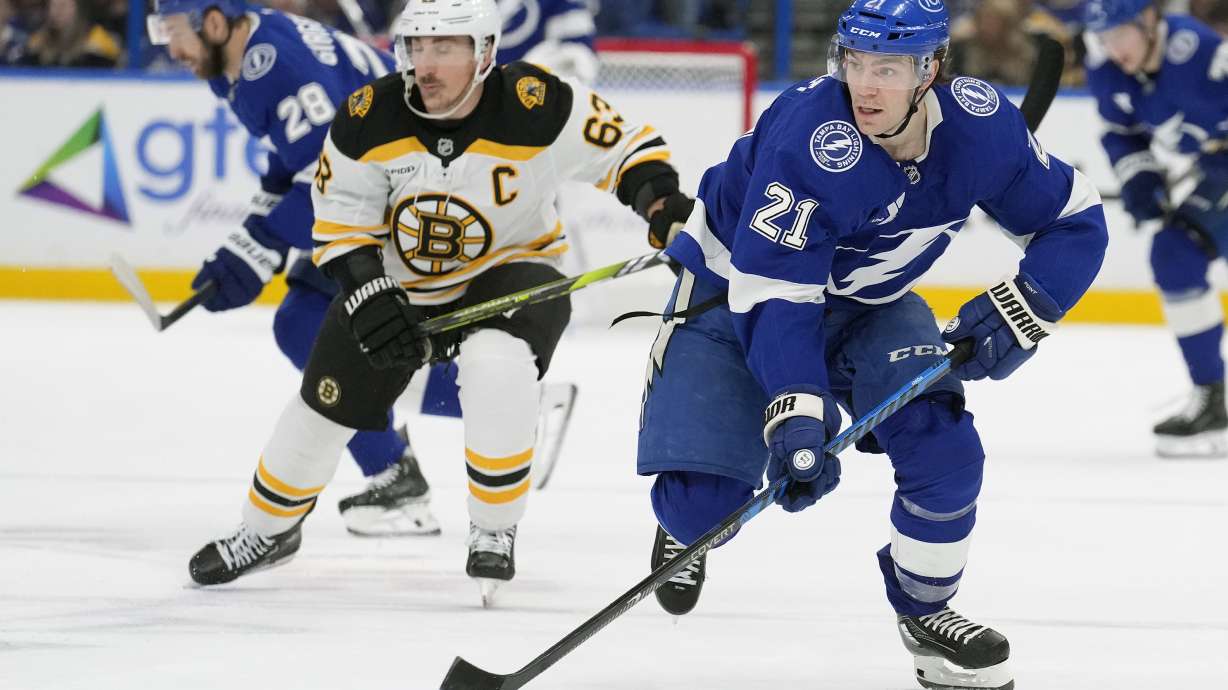 Tampa Bay Lightning center Brayden Point (21) breaks out ahead of Boston Bruins left wing Brad Marchand (63) during the second period of an NHL hockey game Thursday, Jan. 9, 2025, in Tampa, Fla.