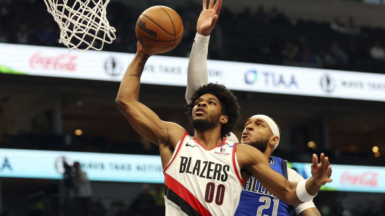 Portland Trail Blazers guard Scoot Henderson (00) shots against Dallas Mavericks' Daniel Gafford (21) in the first half of an NBA basketball game Thursday, Jan. 9, 2025, in Dallas.