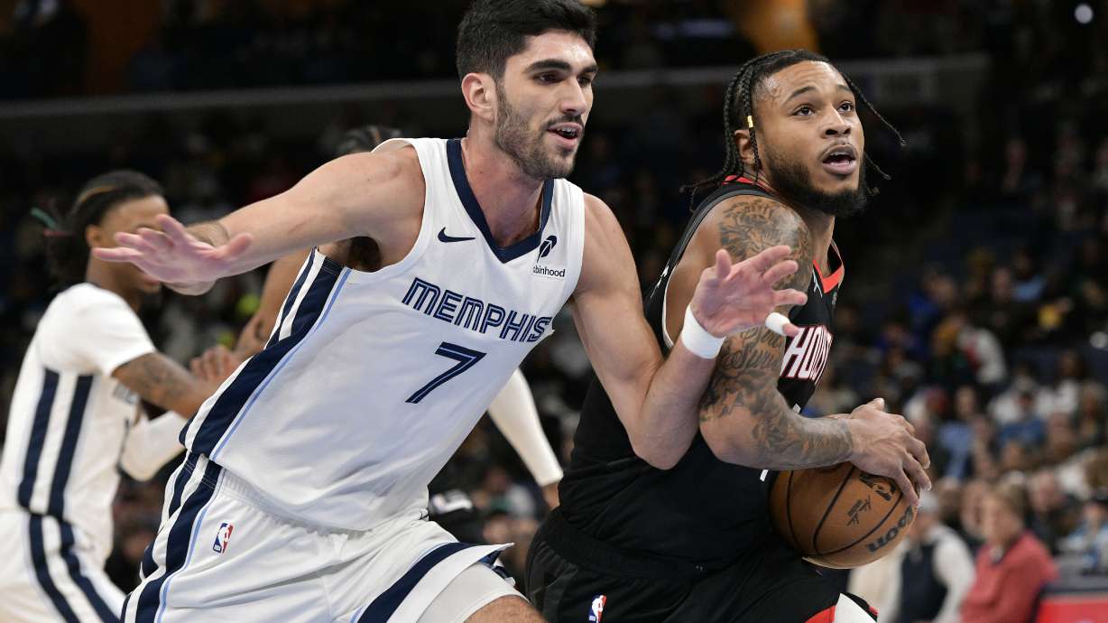 Houston Rockets forward Cam Whitmore, right, handles the ball against Memphis Grizzlies forward Santi Aldama (7) in the first half of an NBA basketball game Thursday, Jan. 9, 2025, in Memphis, Tenn.