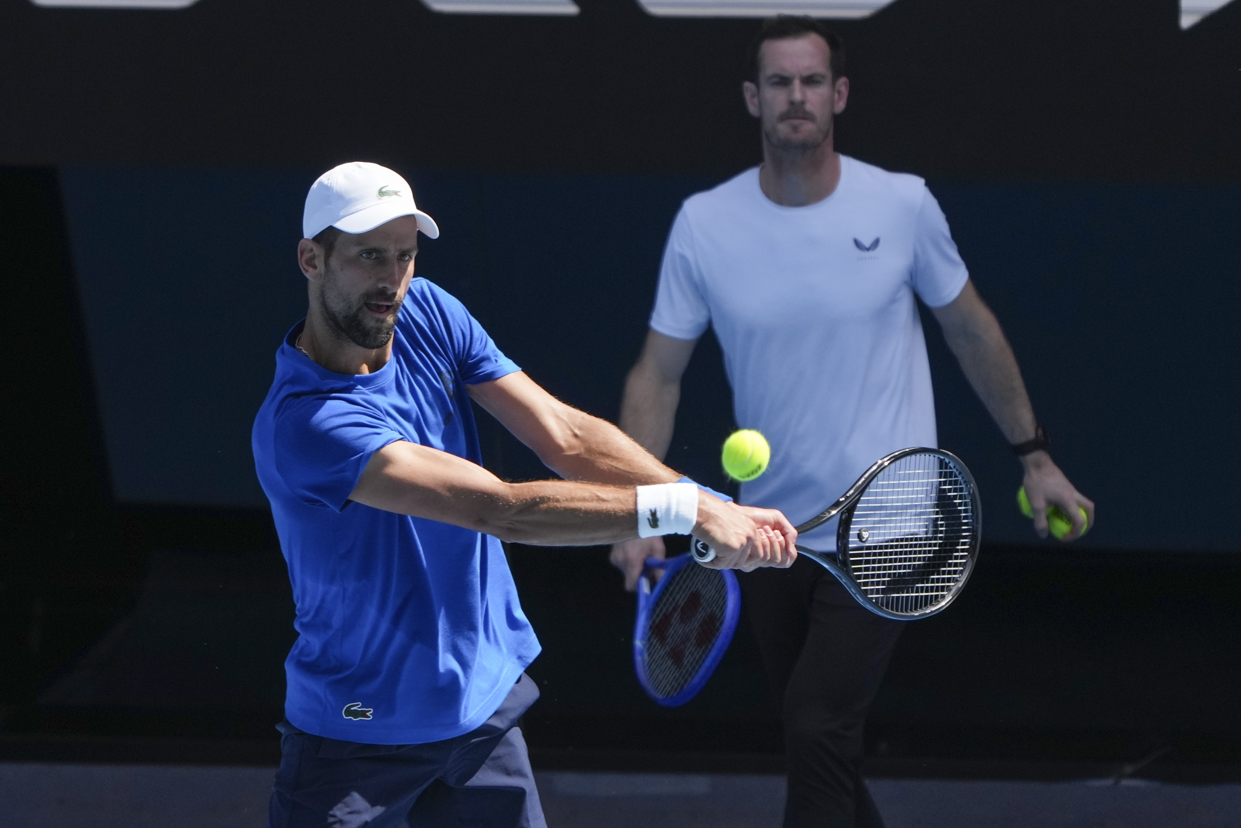 Serbia's Novak Djokovic is watched by his coach Andy Murray, right, during a practice session ahead of the Australian Open tennis championship in Melbourne, Australia, Thursday, Jan. 9, 2025.