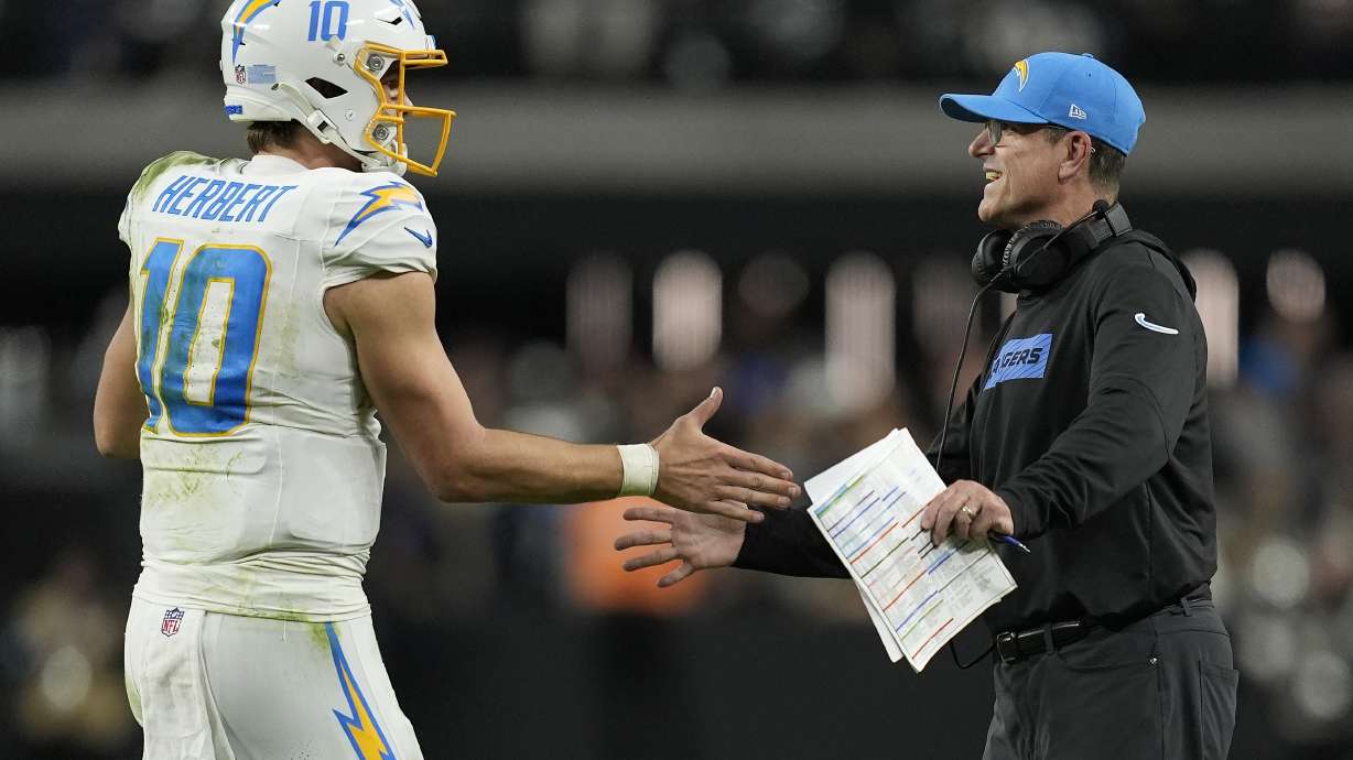 Los Angeles Chargers quarterback Justin Herbert (10) celebrates with head coach Jim Harbaugh during the second half of an NFL football game against the Las Vegas Raiders in Las Vegas, Sunday, Jan. 5, 2025.