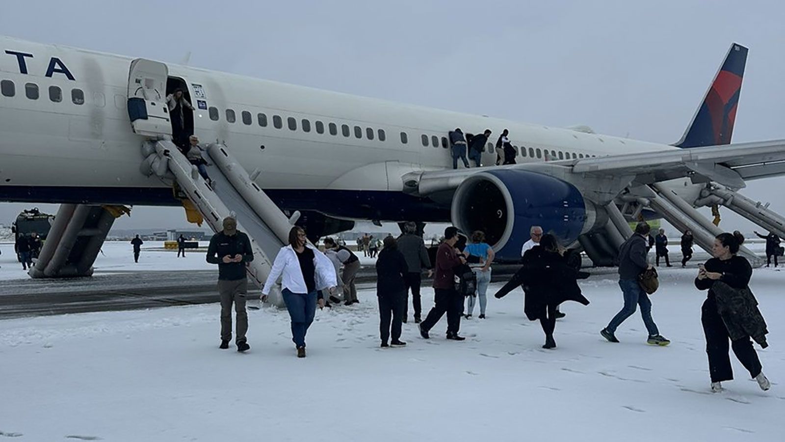 Passengers evacuate Delta flight on slides after aborted takeoff in snowy Atlanta