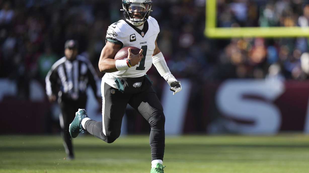 Philadelphia Eagles quarterback Jalen Hurts (1) running with the ball during the first half of an NFL football game against the Washington Commanders, Sunday, Dec. 22, 2024, in Landover, Md.