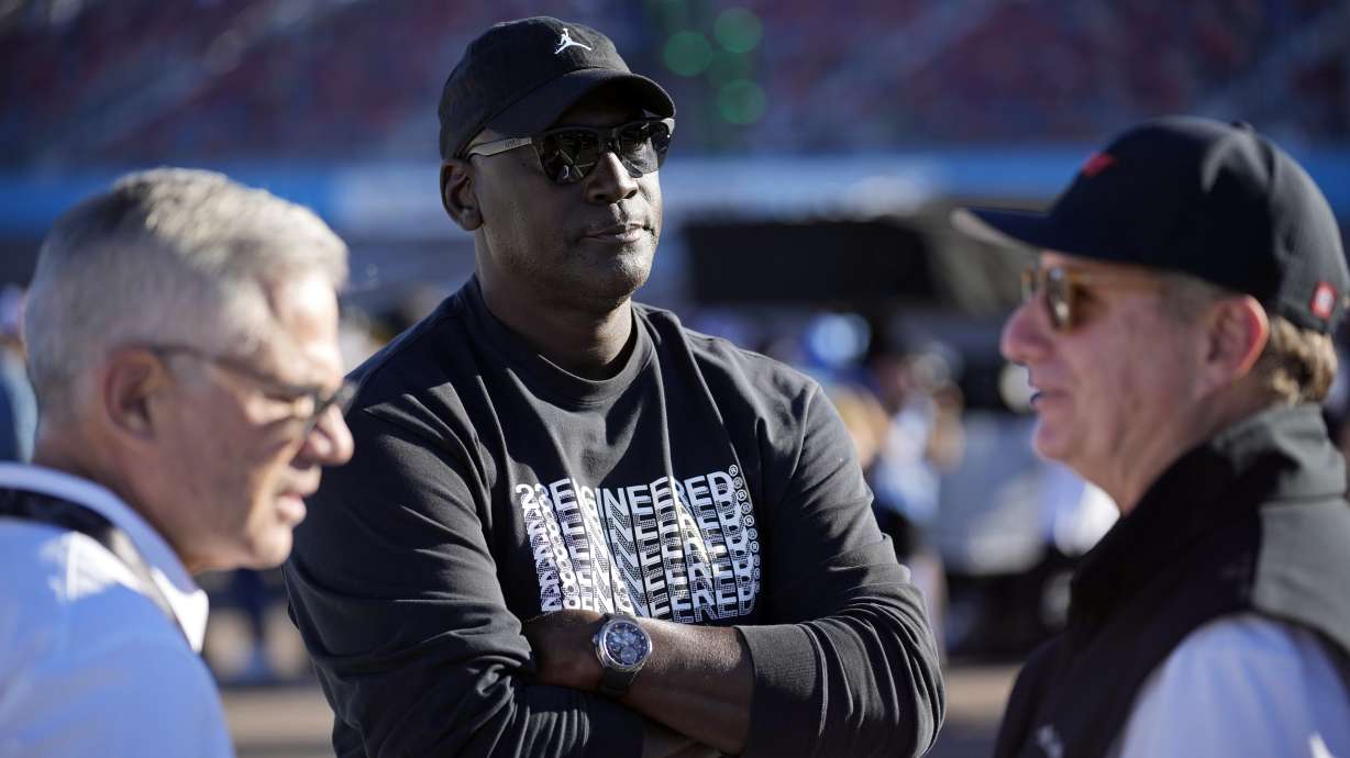 FILE - Michael Jordan, center, and Curtis Polk, left, co-owners of 23XI Racing, watch during qualifying beside 23XI Racing President Steve Lauletta, right, for a NASCAR Cup Series Championship auto race, Saturday, Nov. 9, 2024, in Avondale, Ariz.