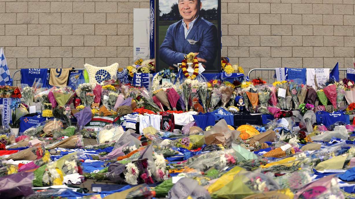 FILE - Tributes from supporters rest at a memorial under a portrait of team owner Vichai Srivaddhanaprabha outside Leicester City Football Club, Monday Oct. 29 2018, in Leicester, England. .