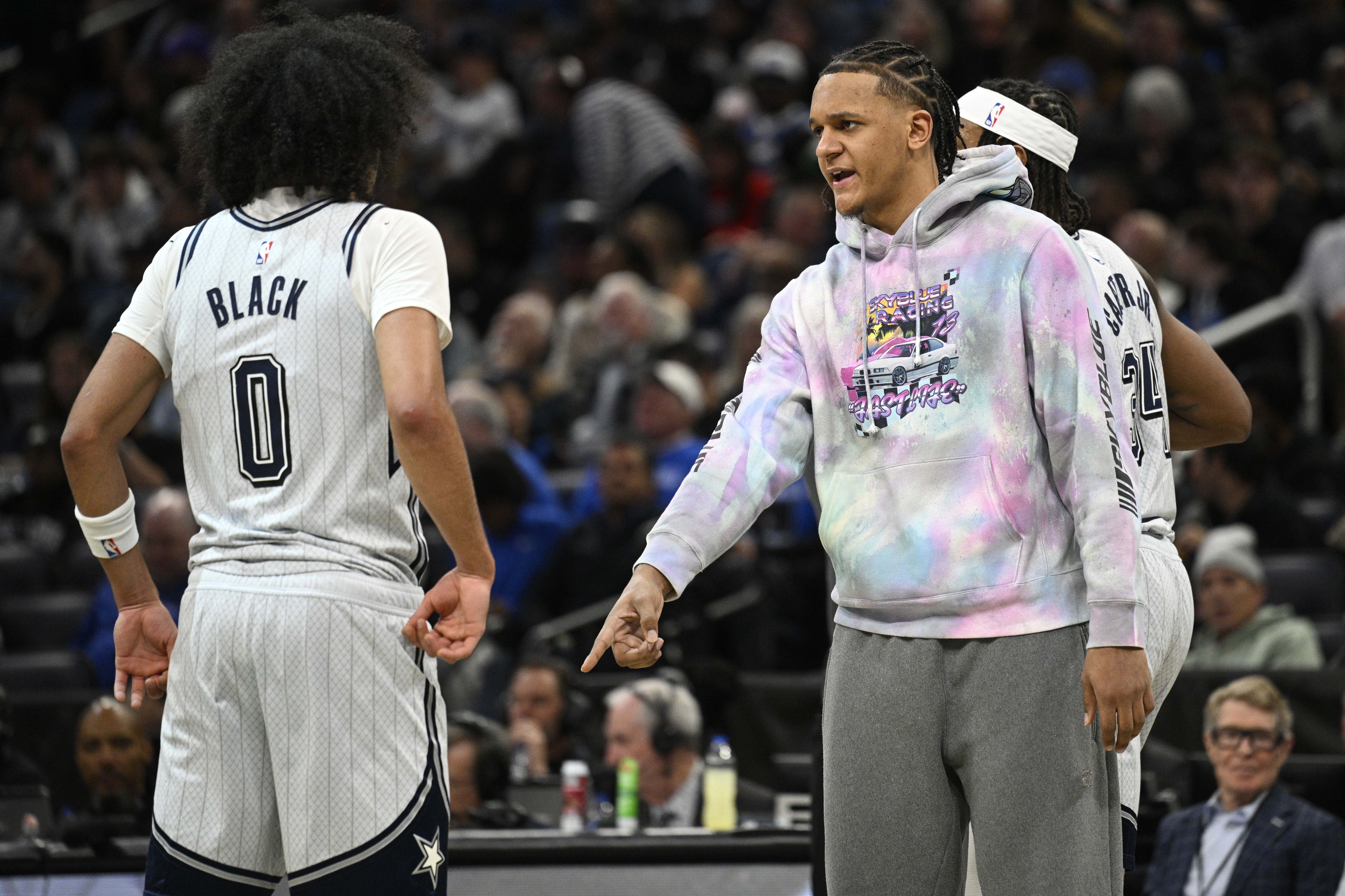 Injured Orlando Magic forward Paolo Banchero, right, gives instructions to guard Anthony Black (0) during the first half of an NBA basketball game against the Minnesota Timberwolves, Thursday, Jan. 9, 2025, in Orlando, Fla.