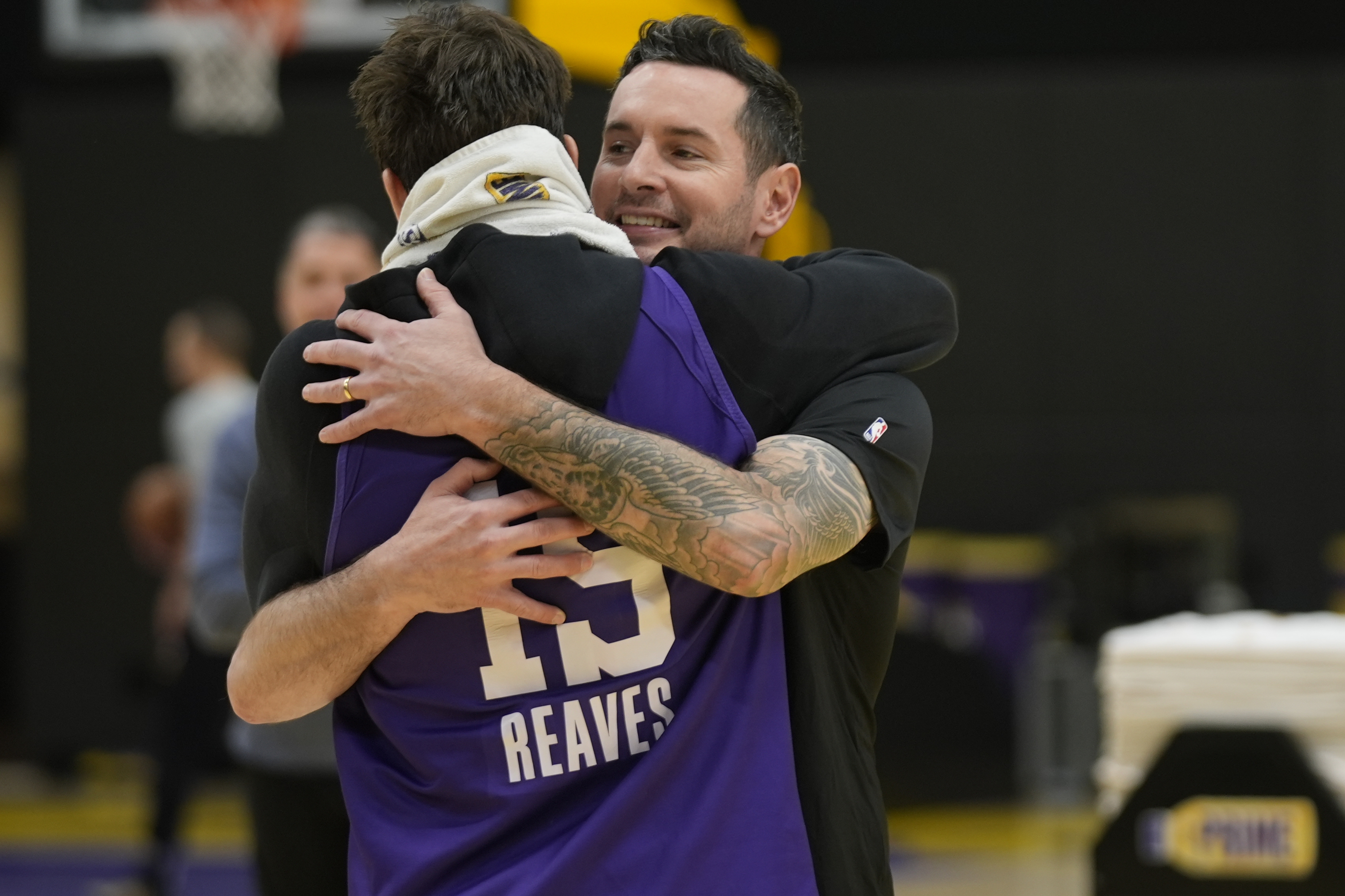 Los Angeles Lakers NBA basketball head coach JJ Redick, right, is hugged by guard Austin Reaves, left before talking to the media about the Pacific Palisades wildfire at a news conference in El Segundo, Calif., Friday, Jan. 10, 2025.