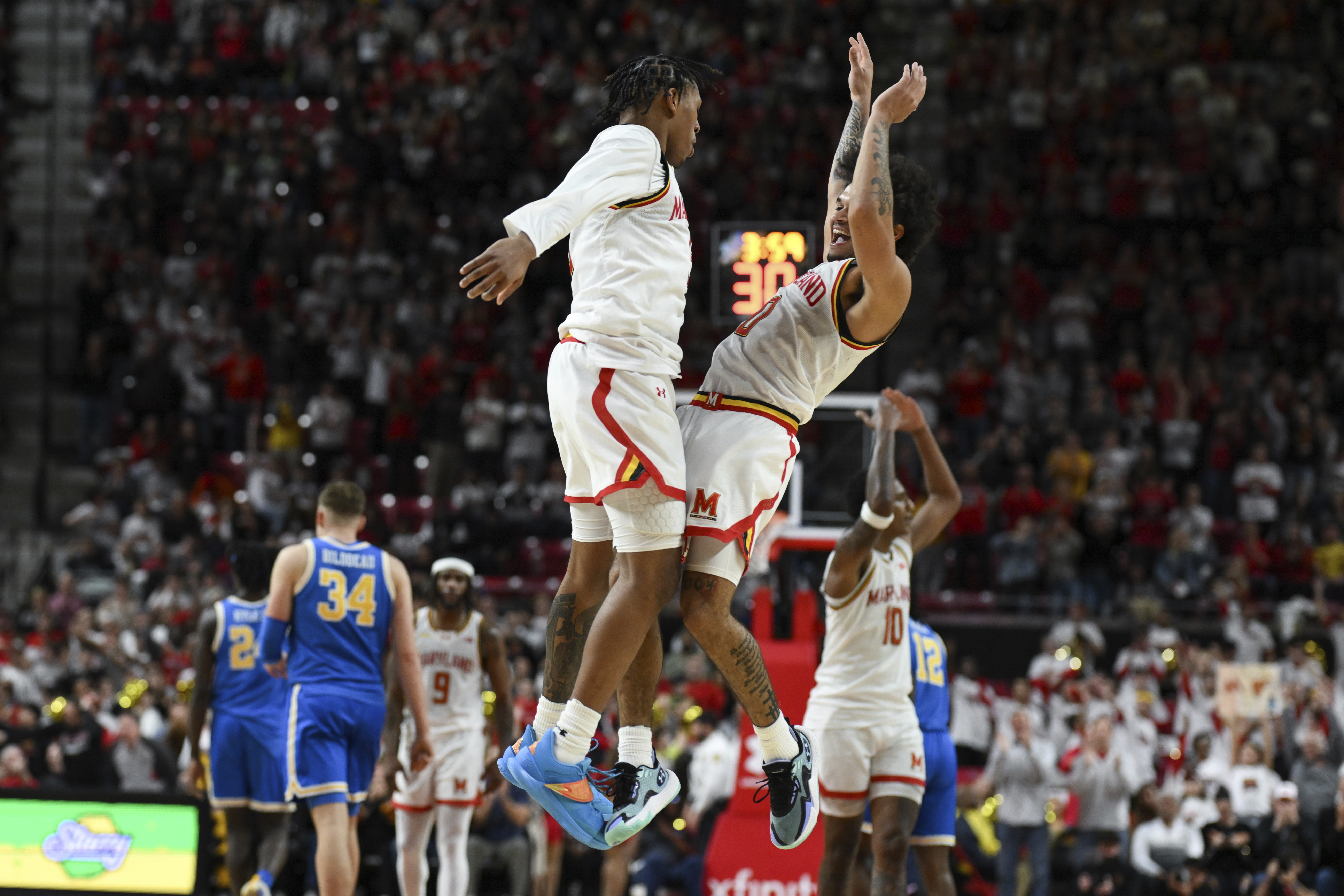 Maryland guard Ja'Kobi Gillespie, center right, celebrates after his 3-point basket with guard DeShawn Harris-Smith, center left, during the second half of an NCAA college basketball game against UCLA, Friday, Jan. 10, 2025, in College Park, Md.