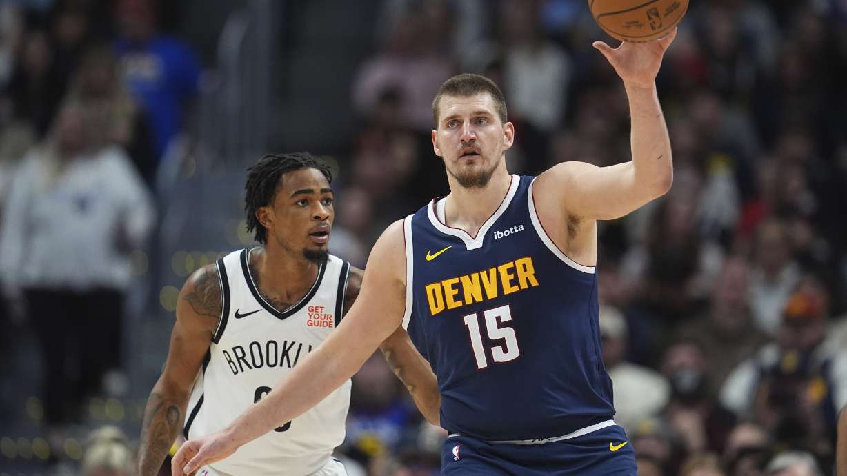 Denver Nuggets center Nikola Jokic, front, fields a pass as Brooklyn Nets center Nic Claxton defends in the first half of an NBA basketball game Friday, Jan. 10, 2025, in Denver.
